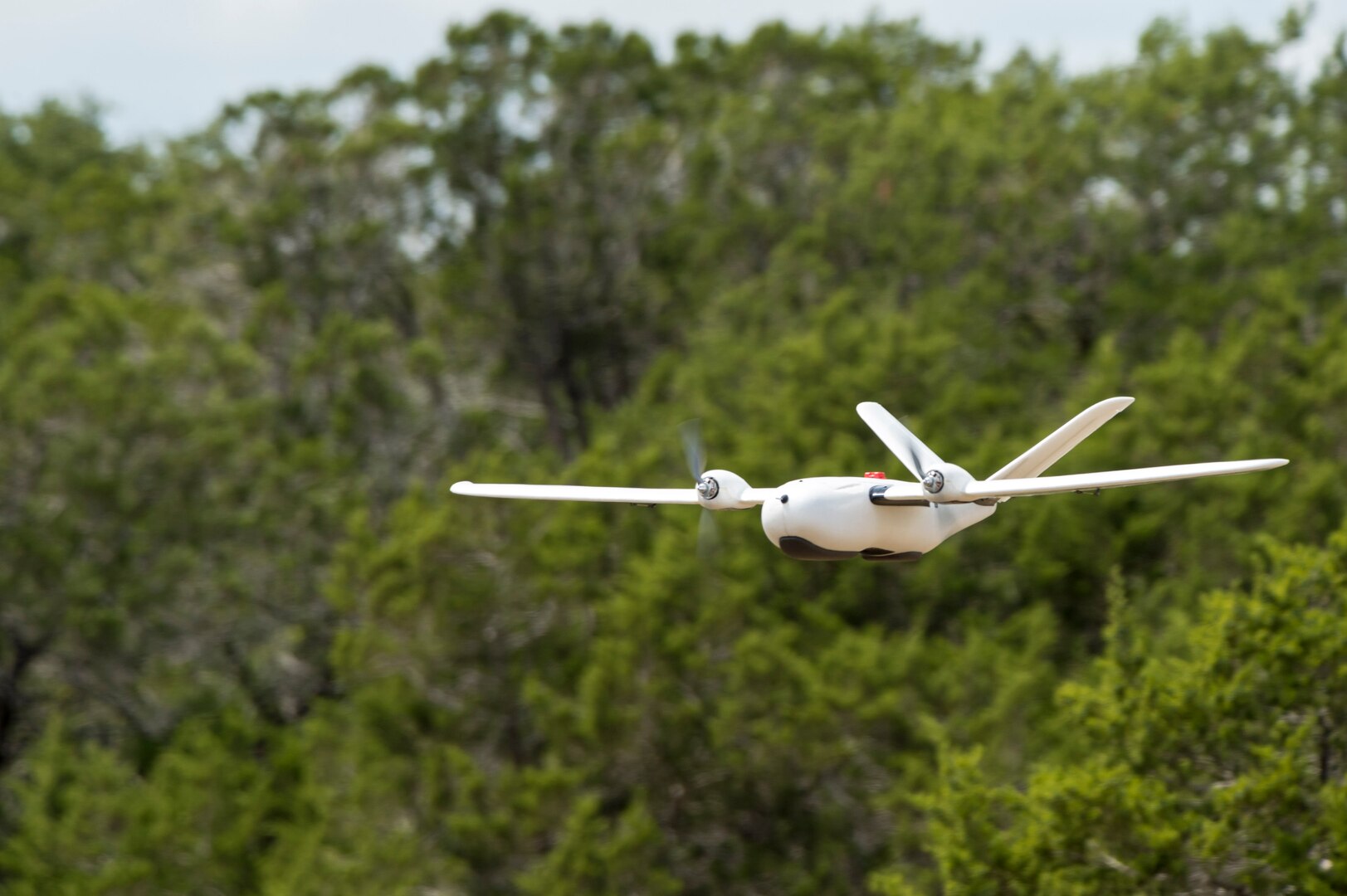 An unmanned aerial system flies over Camp Bullis, Texas, during a field test Sept. 4. The UAS was equipped with Light Detection and Ranging, multi-spectral sensors and machine-learning algorithms to map, survey and inventory habitat for the golden-cheeked warbler. The field test will help the Air Force determine if UAS technology can characterize habitat better, faster and cheaper than current methods.