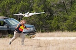Ethan Jacobs, unmanned aerial system engineer, launches a UAS during a field test Sept. 4 at Camp Bullis, Texas. The UAS was equipped with Light Detection and Ranging, multi-spectral sensors and machine-learning algorithms to map, survey and inventory habitat for the golden-cheeked warbler. The field test will help the Air Force determine if UAS technology can characterize habitat better, faster and cheaper than current methods.