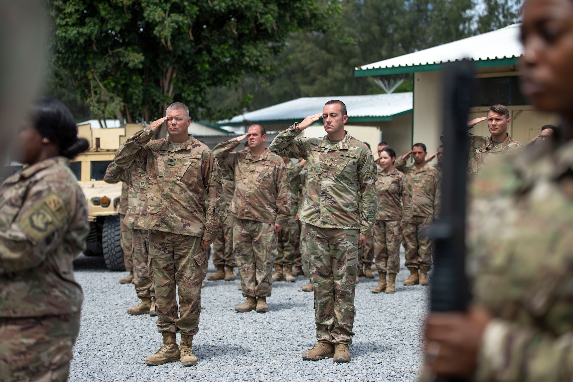 U.S. Air Force Airmen from the 475th Expeditionary Air Base Squadron salute the flag during a ceremony at Camp Simba, Kenya, Aug. 26, 2019. The 475th EABS raised the flag for the first time since the base operating support-integrator mission started in 2017, signifying the change from tactical to enduring operations. (U.S. Air Force photo by Staff Sgt. Lexie West)