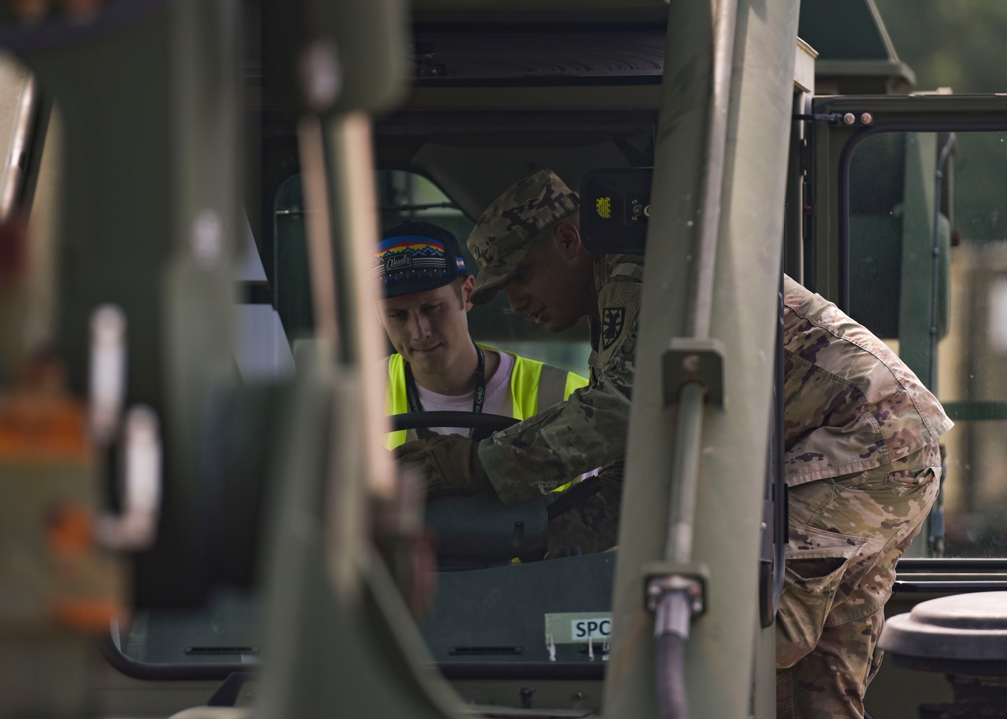 A U.S. Army Soldier teaches a Port of Virginia dockworker how to operate a vehicle during training for a cargo transportation exercise at Fort Story, Virginia, Aug. 20, 2019.