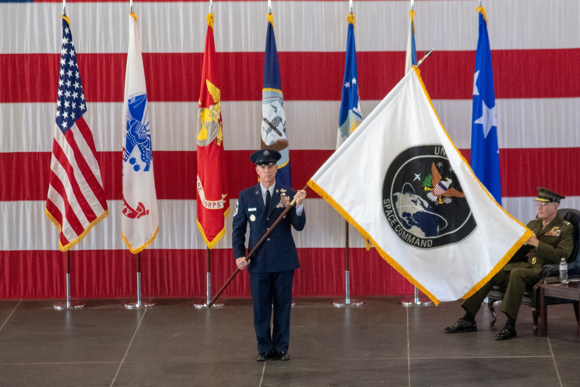 Air Force Chief Master Sgt. Roger A. Towberman, command chief, U.S. Space Command and Air Force Space Command, presents the colors of USSPACECOM during the recognition and establisment ceremony at Peterson Air Force Base, Colorado Sept. 9, 2019.