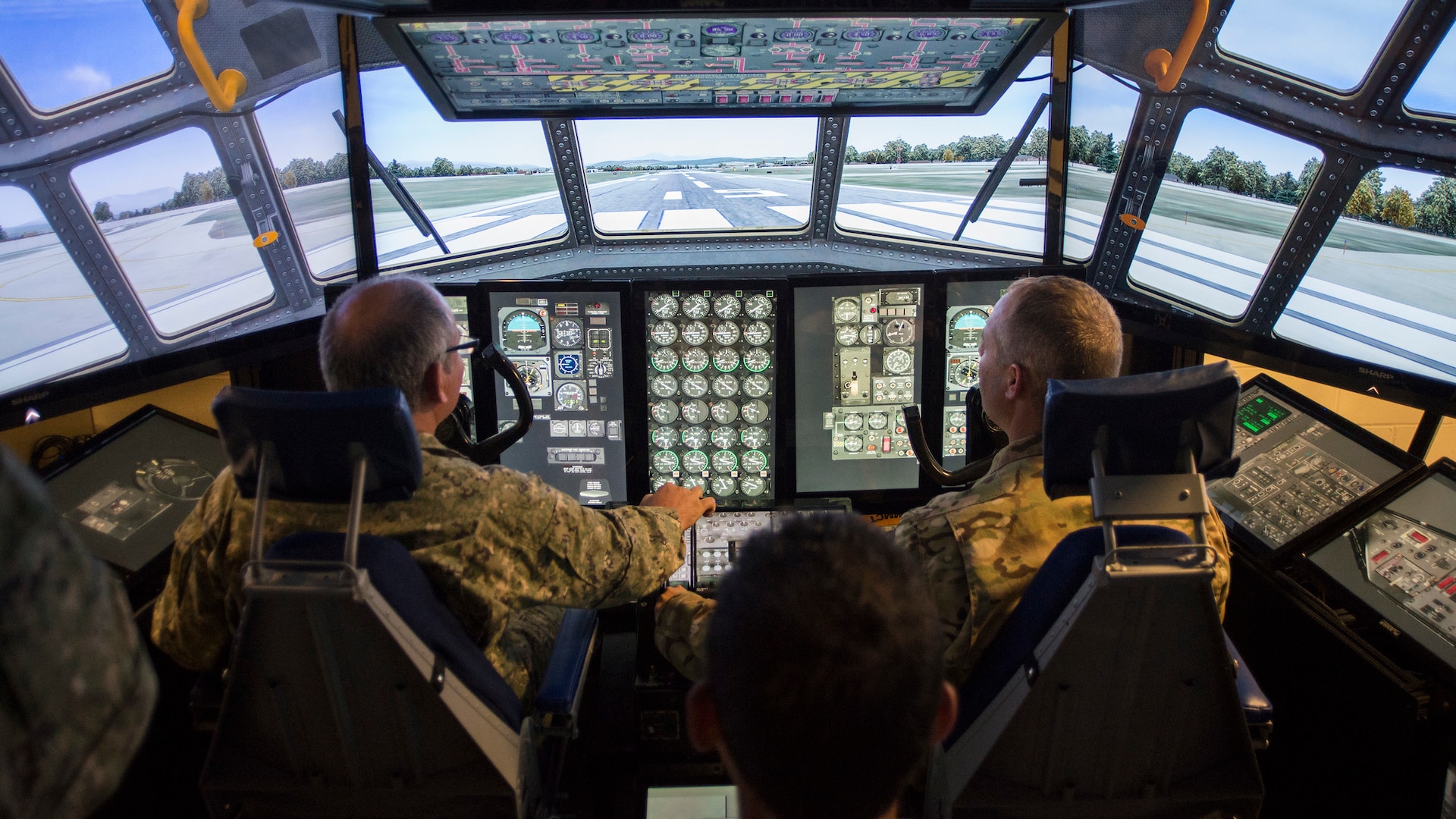 Col. Hugo Parentini, Uruguayan Air Force, and Col. Stephen Gwinn, 103rd Airlift Wing Commander, operate the wing's C-130H Hercules Multi-Mission Crew Trainer (MMCT) during a State Partnership Program visit to Bradley Air National Guard Base, East Granby, Conn. Aug. 15, 2019.