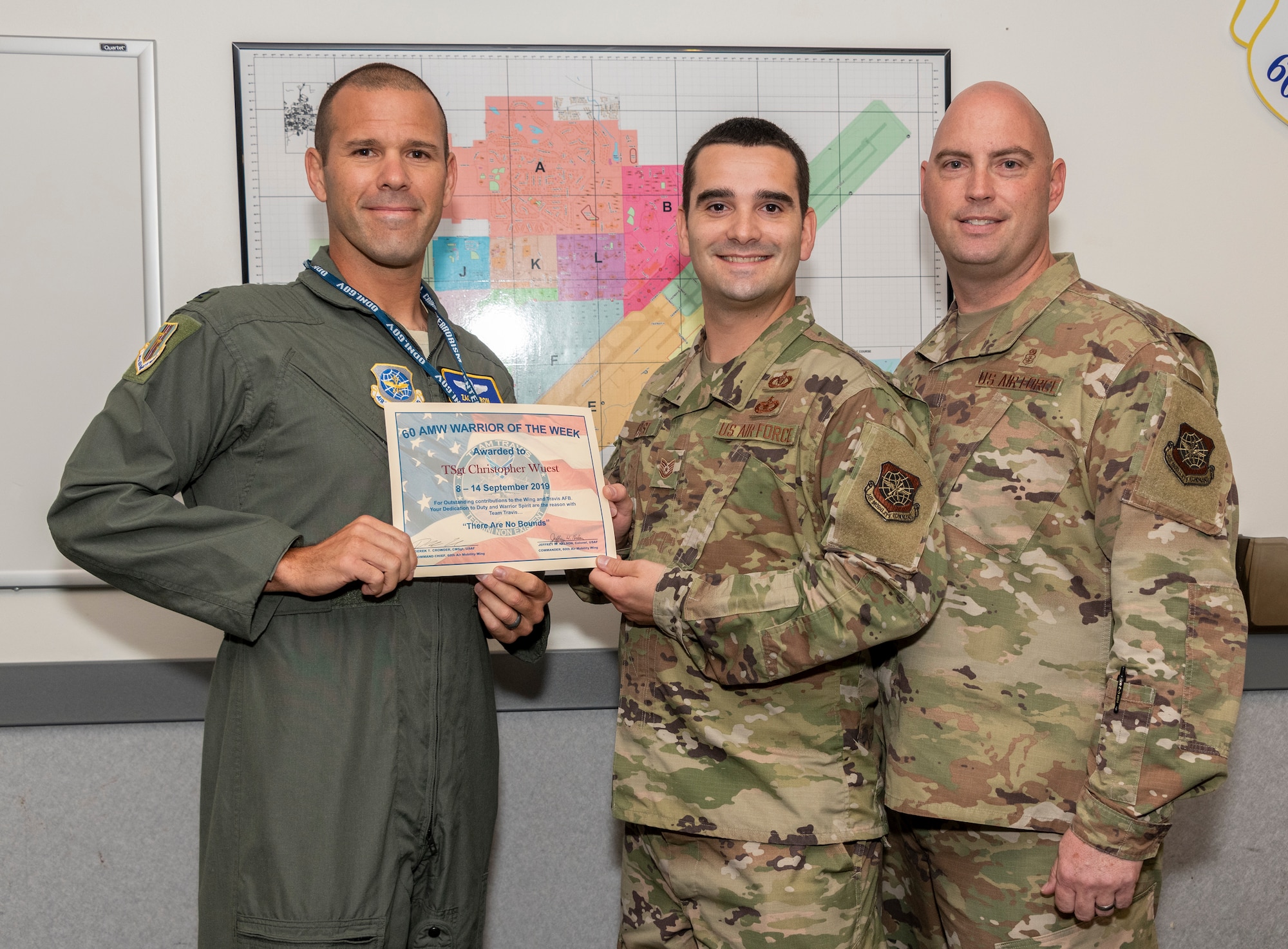 U.S. Air Force Col. Zachery Jiron, left, 60th Air Mobility Wing, vice commander, and Chief Master Sgt. Vincent Brass, right, 60th Medical Group superintendent, recognize Tech. Sgt. Christopher Wuest, 60th AMW Command Post NCO in charge command and control operations reports, as the Warrior of the Week Sept. 10, 2019 at Travis Air Force Base, California. The Warrior of the Week program recognizes an outstanding Travis Airman or noncommissioned officer. (U.S. Air Force photo by Heide Couch)