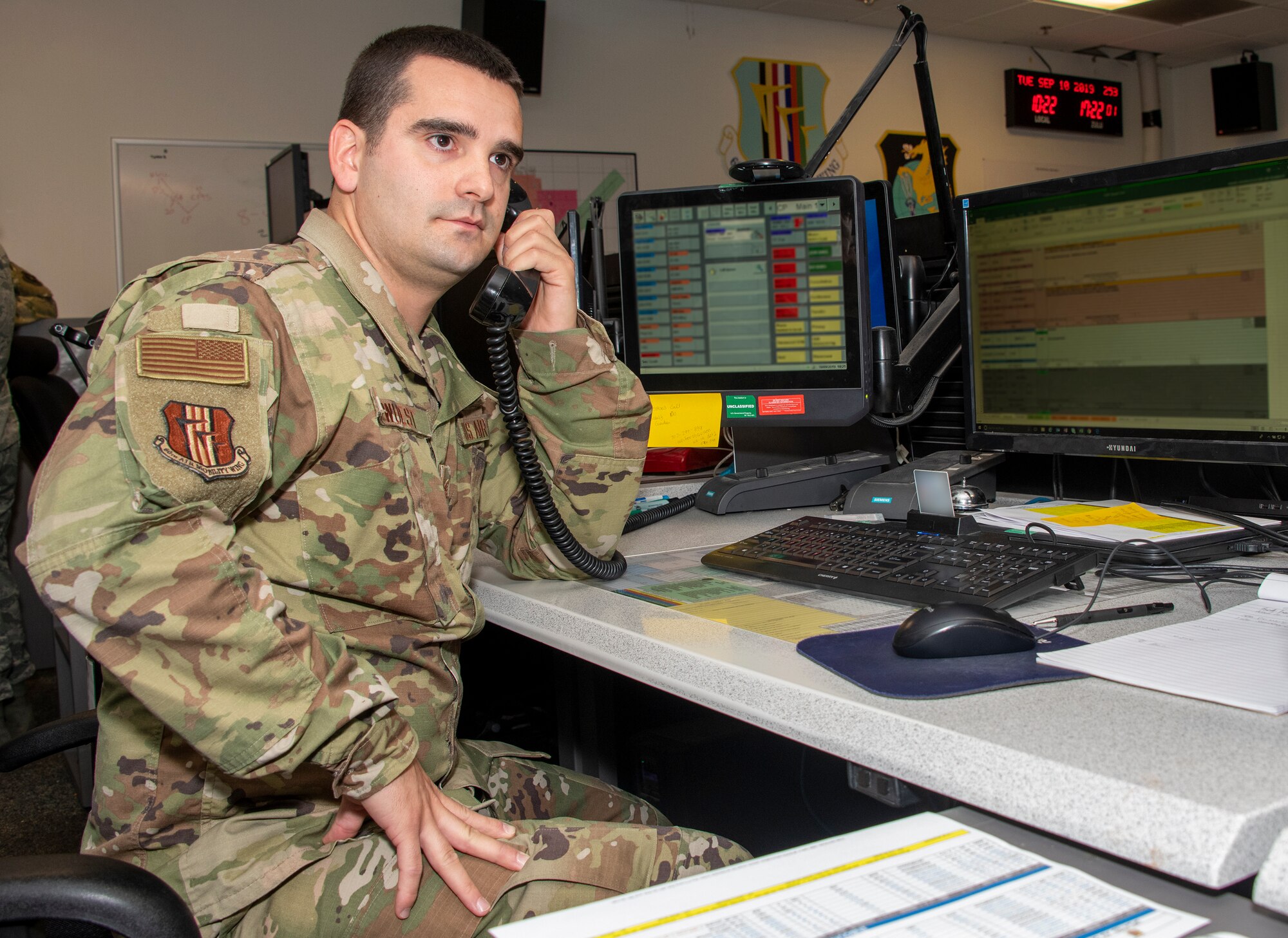 U. S. Air Force Tech. Sgt. Christopher Wuest, 60th Air Mobility Wing Command Post NCO in charge of command and control operations reports, receives an incoming call Sept. 10, 2019, at Travis Air Force Base, California. Wuest is the 60th Air Mobility Wing Warrior of the Week for Sept. 8-14, 2019.  The Warrior of the Week program recognizes an outstanding Travis Airman or noncommissioned officer. (photo altered for security reasons)  (U.S. Air Force photo illustration by Heide Couch)