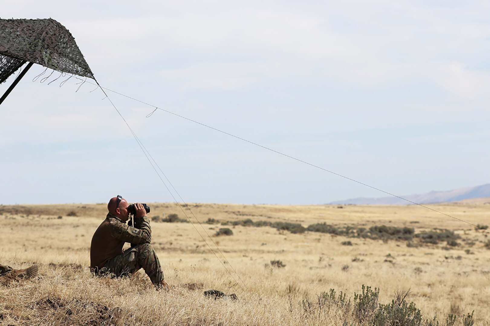 Staff Sgt. Buddy Seibert, of Vergennes, Illinois, a forward observer with the 2nd Battalion, 122nd Field Artillery Regiment, attached to  2nd Battalion, 130th Infantry Regiment, Illinois Army National Guard, surveys the artillery assault course during Rising Thunder 19 at Yakima Training Center, Yakima, Washington, Sept. 3.