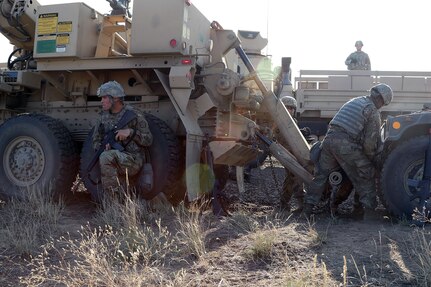 Sgt. Brett Montgomery from the 1844th Transportation Company, 108th Sustainment Brigade, pulls security while the maintenance crew hooks up a downed humvee to their recovery vehicle.