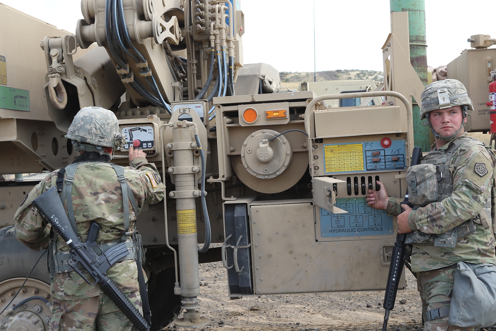Maintenance Soldiers from the 1844th Transportation Company, 108th Sustainment Brigade work on attaching the recovery vehicle's towbar to a downed truck.