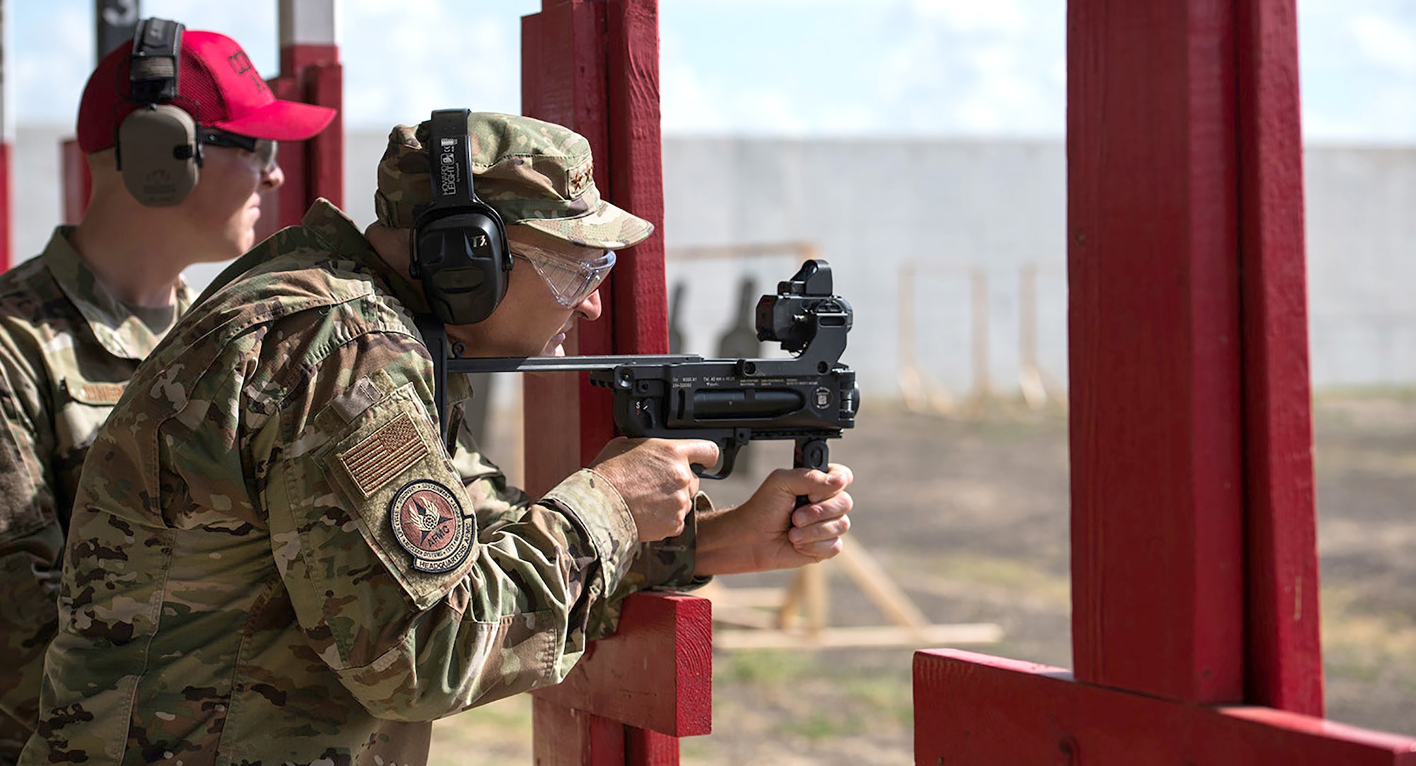 Gen. Arnold W. Bunch, Jr., fires the M320A1 grenade launcher with the ballistic sighting module aiming device with guidance from Staff Sgt. Brett Miner, 37th Training Support Squadron combat arms instructor, at Medina range Sept. 4 during his visit to Air Force Materiel Command Units at Joint Base San Antonio, Texas.