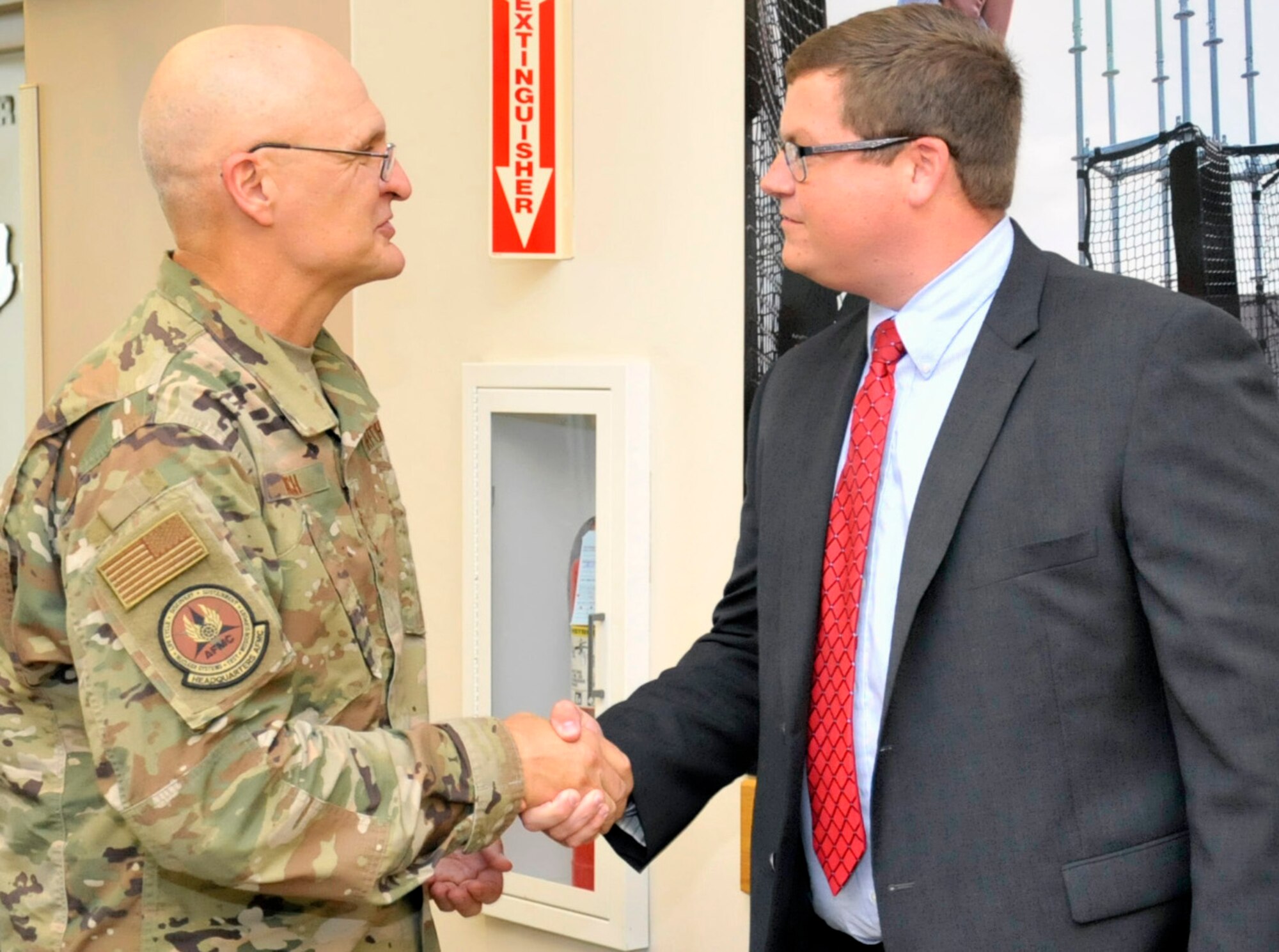 Gen. Arnold W. Bunch, Jr., gives one of his commander’s coins for excellence to Waid Harper of the 338th Specialized Contracting Squadron Sept. 4 at AFIMSC headquarters at  Joint Base San Antonio.