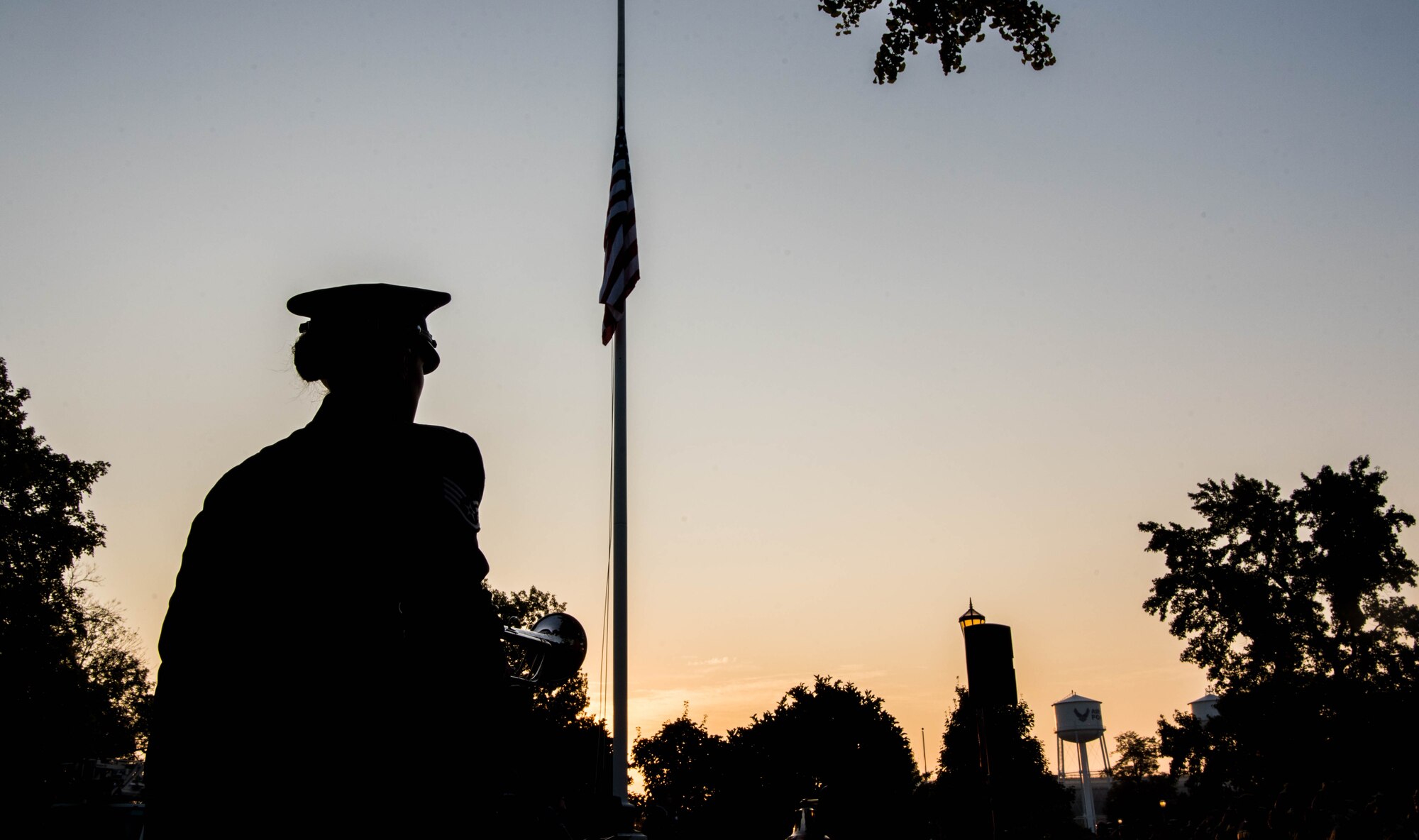 Airman stands in front of flag
