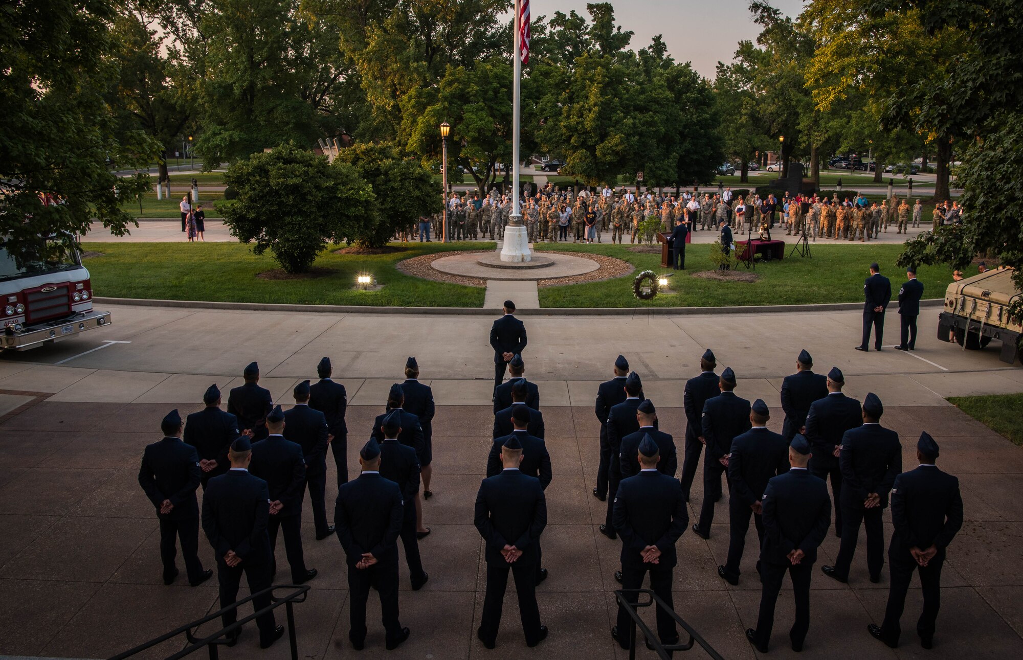 A formation stands behind the U.S. flag