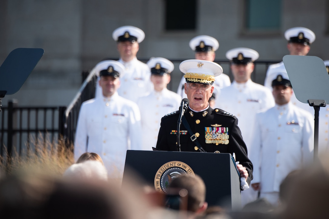 Marine Corps Gen. Joe Dunford, chairman of the Joint Chiefs of Staff, speaks with service members in the back ground.