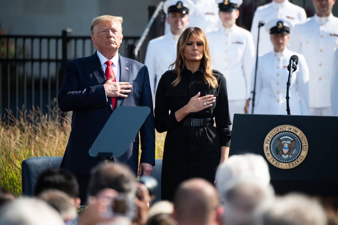 President Donald J. Trump and First Lady Melania Trump stand side by side with their hands on their hearts.