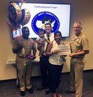 Norfolk Naval Shipyard Deputy Commander Capt. Daniel Rossler and Command Master Chief Gene Garland recongnizes Arianna Reid as Norfolk Naval Shipyard's newest ombudsman.