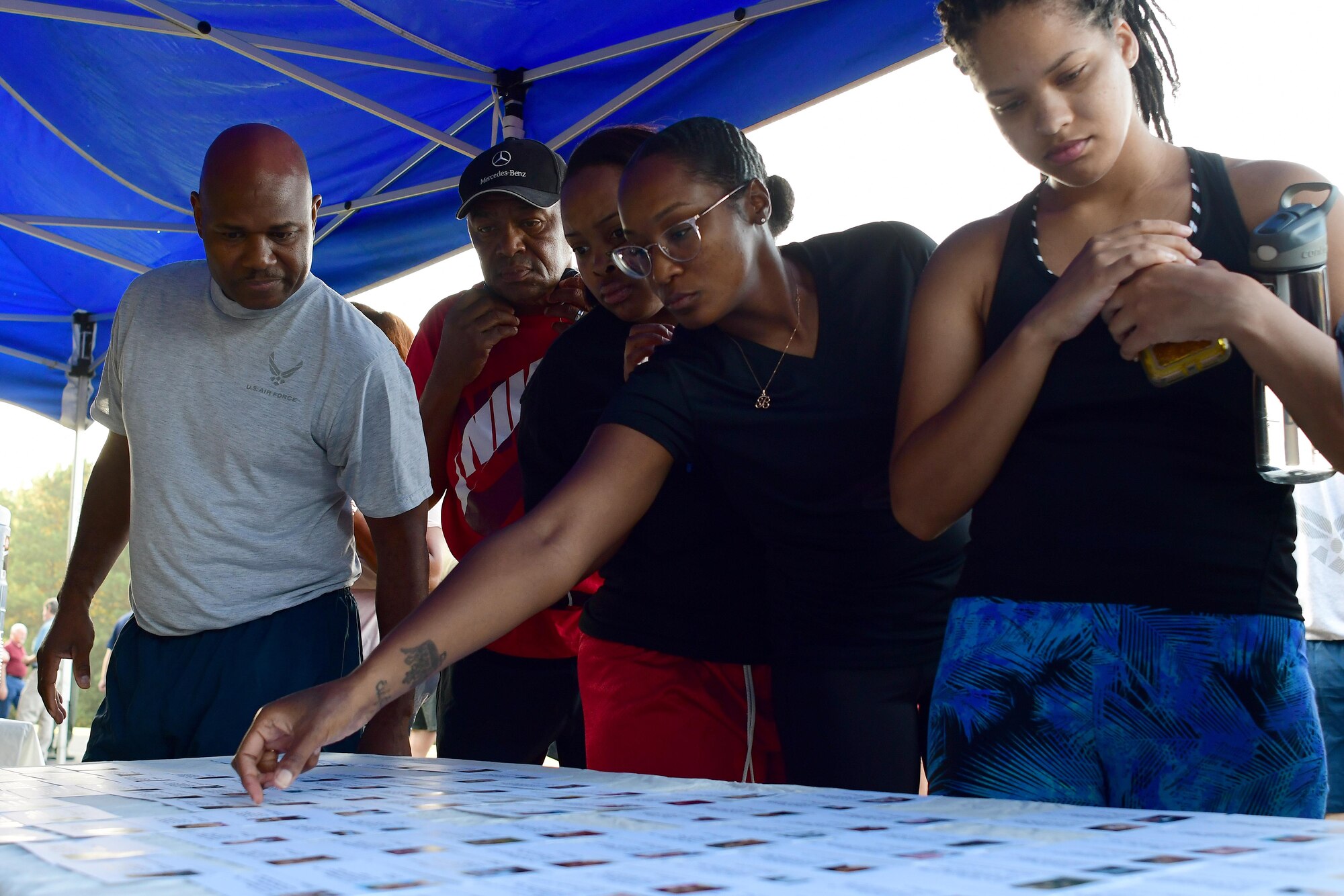 Participants in this year's Sept. 11 Memorial Walk pick up information cards at a table by the base track on Sept. 11, 2019.