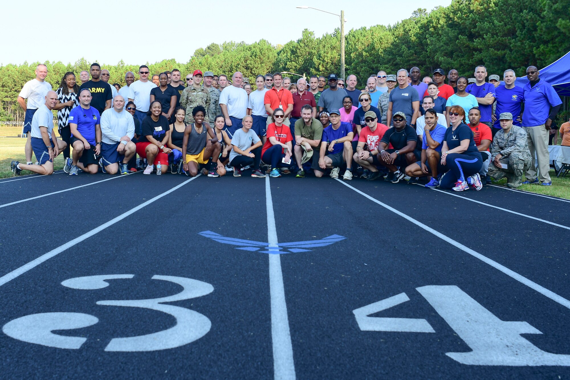 Participants in this year's Sept. 11 Memorial Walk pose for a photo at the base track Sept. 11, 2019.