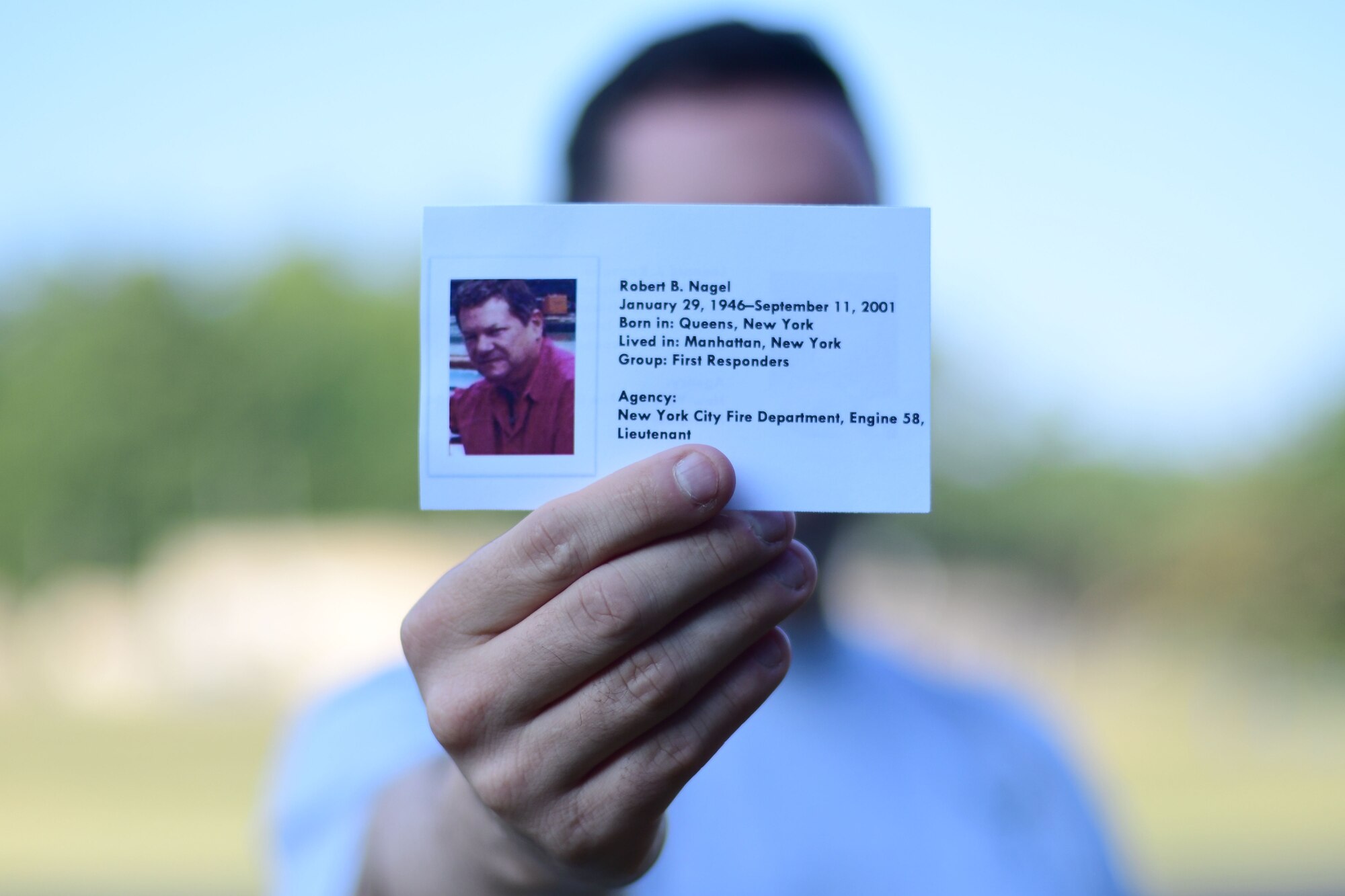 First Lt. Alan Abernethy, 94th Airlift Wing public affairs officer, holds up an information card at the base track on Sept. 11, 2019.