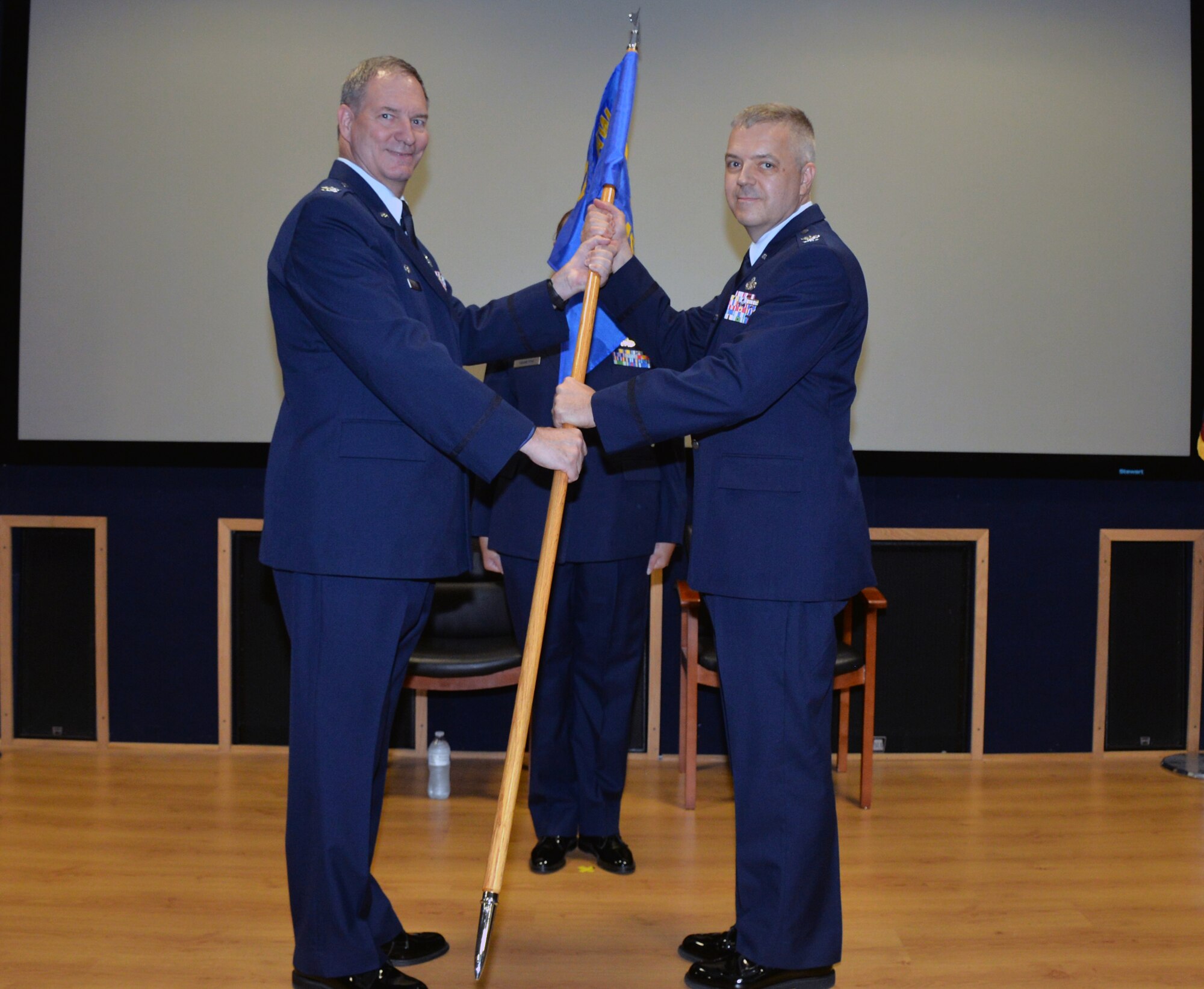 Col. Terry W. McClain, 433rd Airlift Wing commander, presents the 433rd Mission Support Group guidon to Col. Wayne M. Williams as he assumes command at Joint Base San Antonio-Lackland, Texas Sept. 7, 2019.