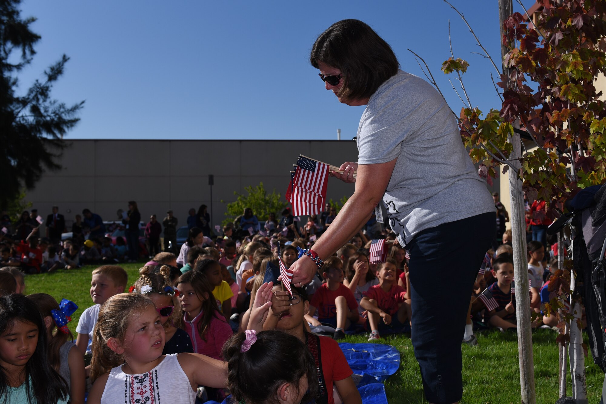 American Flags are handed out to children attending the Remembrance Day Freedom Walk Sept. 11, 2019, at Travis Air Force Base, California. The walk commemorated those who lost their lives on 9/11. (U.S. Air Force photo by Airman 1st Class Cameron Otte)