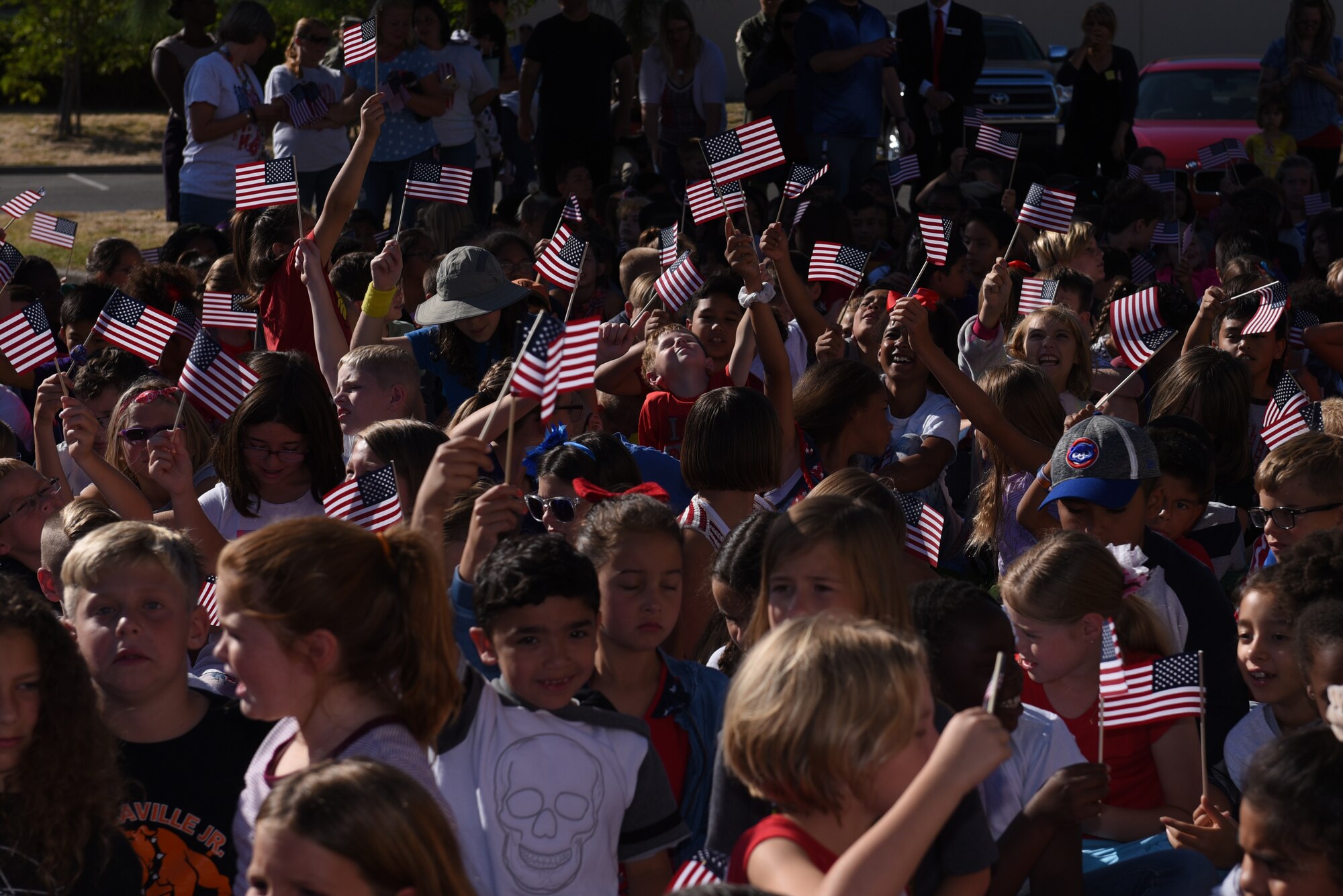 Children attending the Remembrance Day Freedom Walk wave American flags Sept. 11, 2019, at Travis Air Force Base, California. The walk commemorated those who lost their lives on 9/11. (U.S. Air Force photo by Airman 1st Class Cameron Otte)