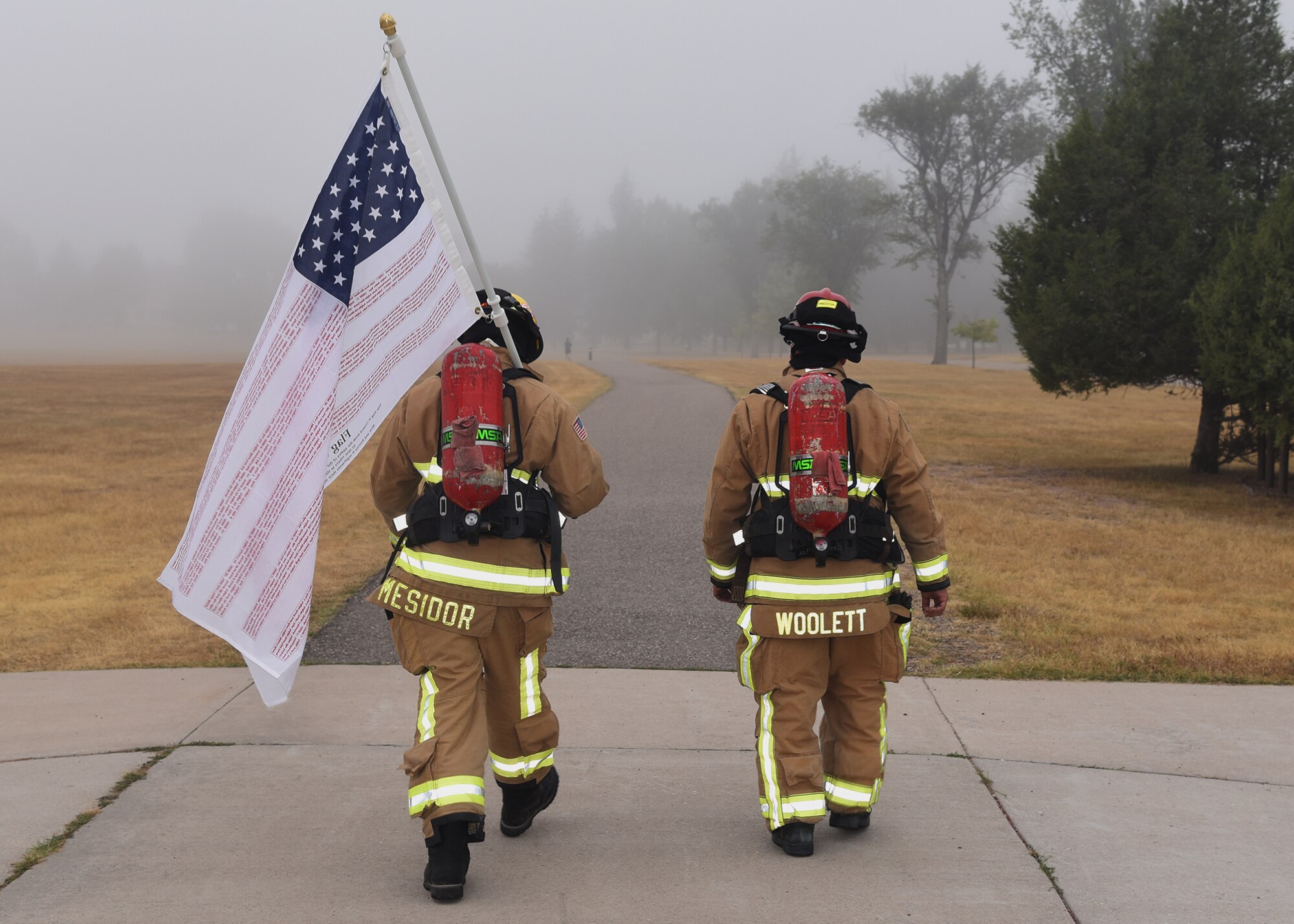 Senior Airman Ralph Mesidor and Cody Woolett, members of the Warren Fire Department, carry the Flag of Heroes around the base parade field Sept. 11 on F. E. Warren Air Force Base. Firefighters conducted the 24 hour vigil in firefighter gear honoring those who were killed in the attacks of Sept. 11, 2001.
