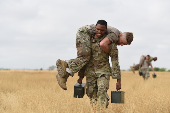 Airman 1st Class Leomar Perez, defender with the 890th Security Forces Squadron, fireman carries Airman 1st Class Jacob Boyett from the 890th Security Forces Squadron, along with two ammo cans during the Crow Creek Challenge Sept. 6, 2019, at F. E. Warren Air Force Base, Wyo. The obstacles seen throughout the day included heavy lifting, running, and calisthenic exercises. (U.S. Air Force photo by Senior Airman Nicole Reed)