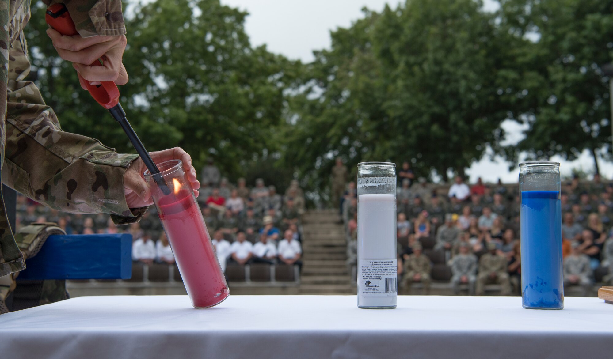 Col. Carey Jones, 47th Operations Group commander, lights a candle during a 9/11 memorial ceremony at Laughlin Air Force Base, Texas, Spet. 11, 2019. Three candles were lit during the ceremony: the red candle in commemoration of all the victims, heroes, survivors, and families who lost loved ones during 9/11; the white candle was lit for all families of victims who were touched by this tragic event which changed so many people’s lives for the worse; and the blue candle was lit for justice, loyalty, perseverance and reverence to God. (U.S. Air Force photo by Staff Sgt. Benjamin N. Valmoja)
