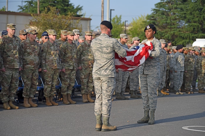 Airman 1st Class Aubrey Mathis and Airman 1st Class HarleyHall, 8th Security Forces Squadron members, prepare to fold the American flag during the September 11 Remembrance ceremony at Kunsan Air Base, Republic of Korea, Sept. 11, 2019. The ceremony was held in remembrance of the 2,977 people who lost their lives on Sept. 11, 2001, in New York City, Washington, D.C., and outside Shanksville, Pennsylvania. The ceremony included a ringing of a bell, F-16 Fighting Falcon flyover and flag folding and presentation. (U.S. Air Force photo by Staff Sgt. Mackenzie Mendez)
