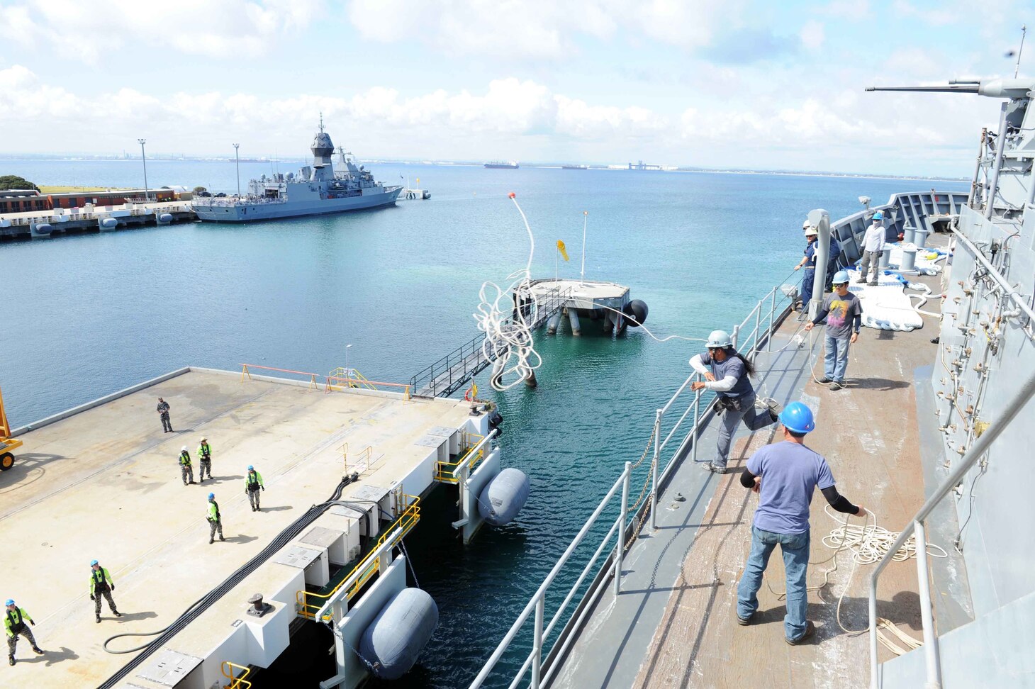 FREMANTLE, Australia (Sept. 11, 2019) - Able Seaman Genaro Cuico, a Military Sealift Command civilian mariner assigned to the submarine tender USS Emory S. Land (AS 39), tosses a line to the pier as the ship prepares to moor at HMAS Stirling in Fremantle, Australia, Sept. 11. Land is in Fremantle for a scheduled port visit to conduct peacetime exercises with the Royal Australian Navy Submarine Service.