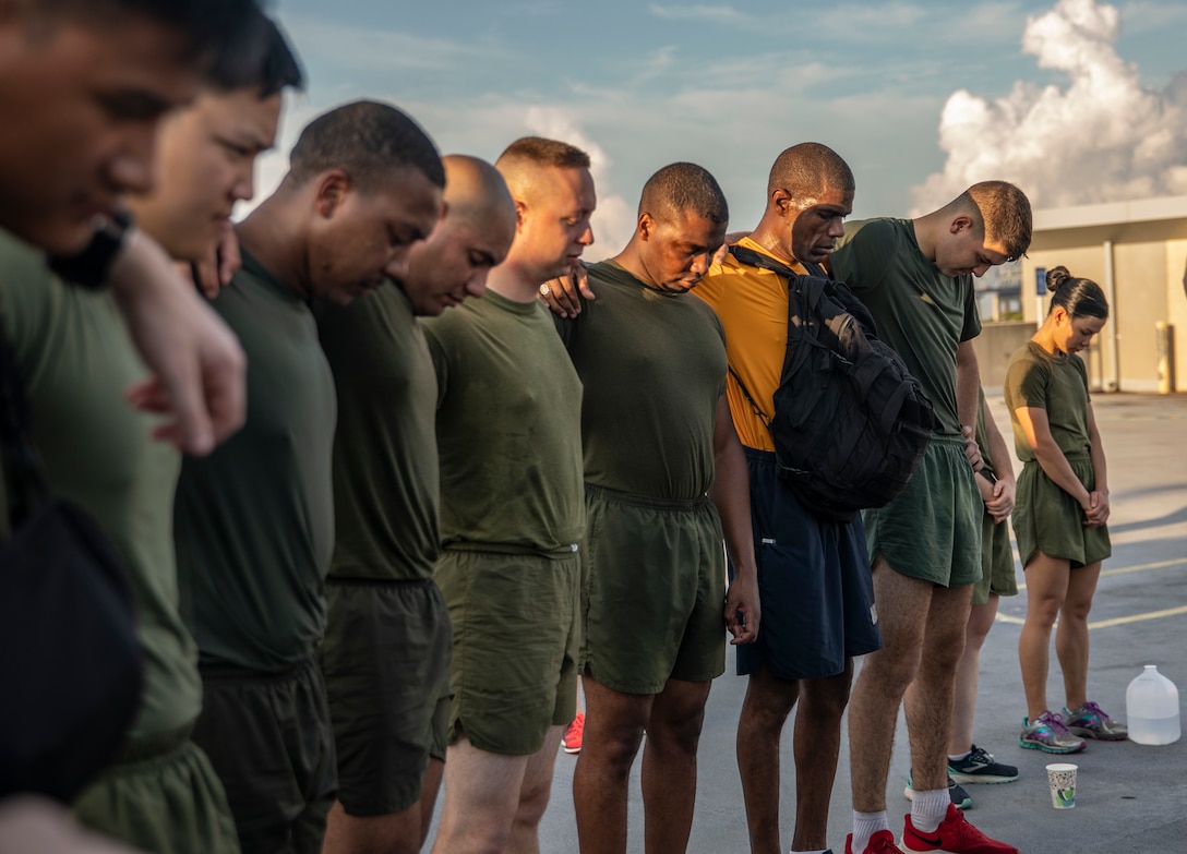 U.S. Marines and Sailor with Marine Forces Reserve bow their heads in silence, in remembrance of 9/11 after a Total Force Fitness event at Marine Corps Support Facility New Orleans, Sept. 11, 2019. This was part of a MARFORRES Total Force Fitness event inspired by the 18th anniversary of 9/11 and the efforts of the first responders at the World Trade Center. The exercise consisted of Marines ascending and descending a five story stairwell 11 times, resulting in a total of 110 stories, which is equivalent to the height of the World Trade Center. (U.S. Marine Corps photo by Pfc. Leslie Alcaraz)
