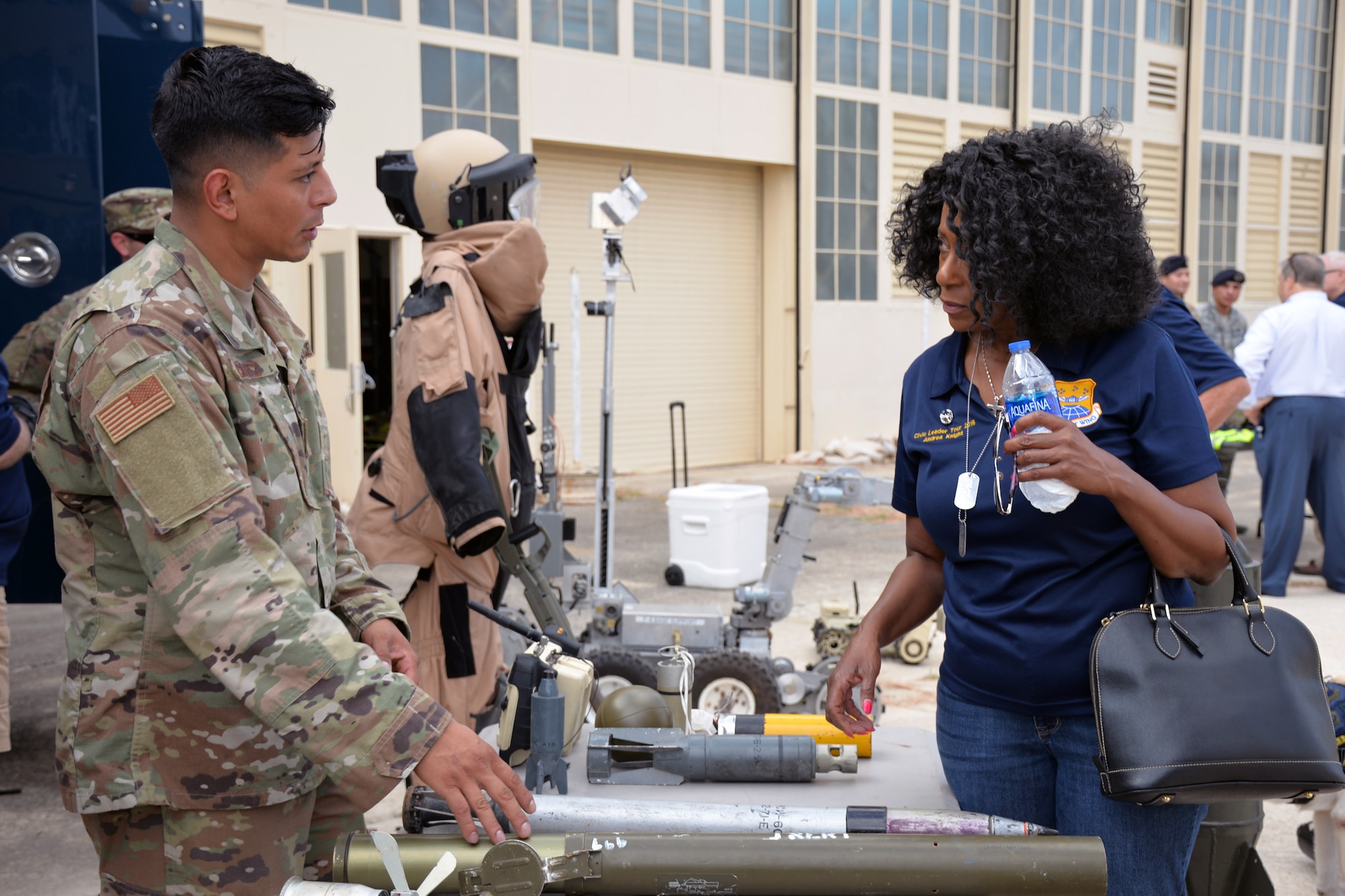 Staff Sgt. Oscar Chavez, 433rd Civil Engineer Squadron explosive ordnance specialist, talks with Honorary Commander Andrea Knight, Frost Bank assistant vice president, about weapons on display during a tour of the 433rd Mission Support Group at Joint Base San Antonio-Lackland, Texas Sept. 7, 2019.
