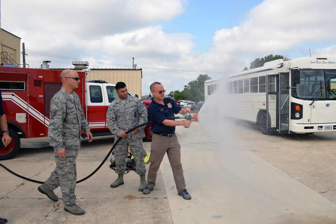 Steve Young, VIA Metropolitan Transit vice president of information technology, experiences discharging a fire hose during a tour of the 433rd Mission Support Group at Joint Base San Antonio-Lackland, Texas Sept. 7, 2019.