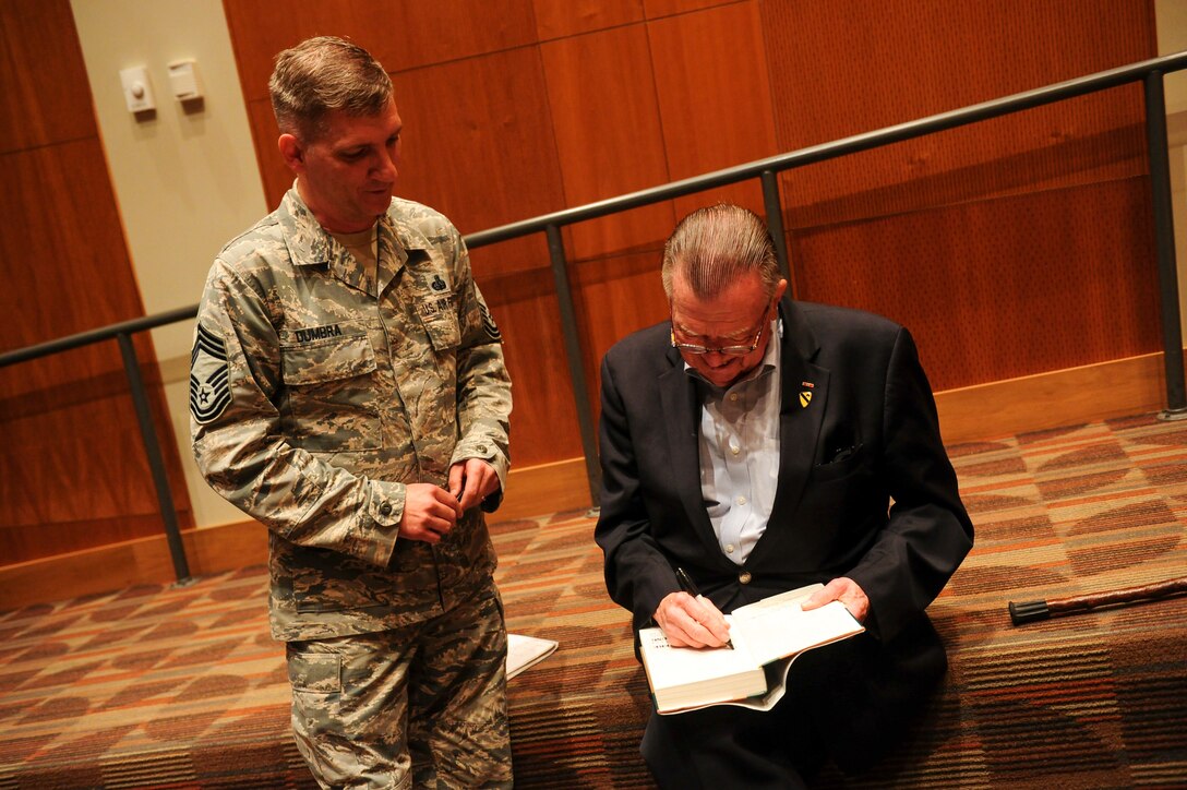 War correspondent and author Joseph Galloway signs a copy his book “We Were Soldiers Once…and Young” for Chief Master Sgt. Dominic Dumbra, Communications and Information superintendent, Aug. 27. Galloway spoke to the National Air and Space Intelligence Center about the experiences described in the book, which he co-wrote alongside Lt. Gen. Harold Moore.  “We Were Soldiers Once…and Young” tells the story of the Battle of the Ia Drang and went on to inspire the movie “We Were Soldiers.” (U.S. Air Force photo by Senior Airman Michael Hunsaker)