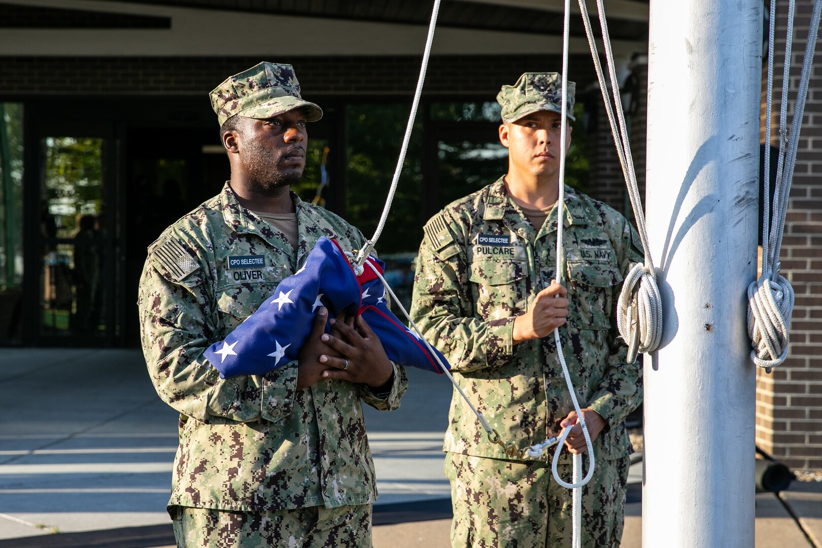 Chief Selects Deshawn Oliver and Nathaniel Pulcar prepare to raise the National Ensign during a Patriots Day ceremony at Norfolk Naval Shipyard Sept. 11, 2019.