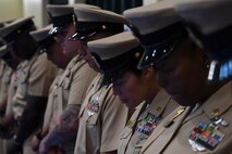 Sailors bow their heads for the invocation during a chief petty officer pinning ceremony held on board Naval Support Activity Bahrain. 39 Sailors from U.S. Naval Forces Central Command, Naval Support Activity Bahrain, and commands located throughout the U.S. 5th Fleet area of operations received their anchors.
