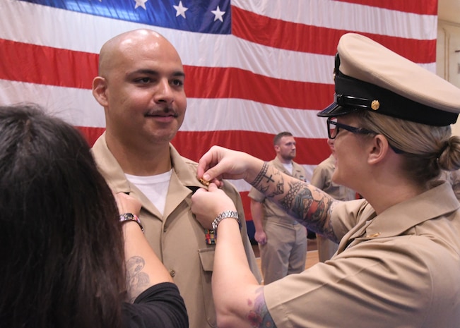 hief Cryptoplogic Technician (Technical) Eric Dejesus has anchors pinned on by his wife, left, and Senior Chief Cryptologic Technician (Collection) Hannah Ryder during a chief petty officer pinning ceremony held on board Naval Support Activity Bahrain. 39 Sailors from U.S. Naval Forces Central Command, Naval Support Activity Bahrain, and commands located throughout the U.S. 5th Fleet area of operations received their anchors.