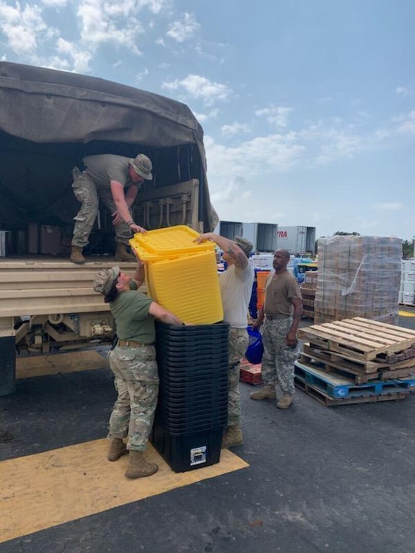 Combat Medic Sgt. Wesley Brantley of the North Carolina National Guard (standing in the truck) and team members Spc. Ruben Baca (right) and Spc. Kaileigh Deanda (left), of the 105th Engineering Battalion, Headquarters and Headquarters Company, in Raeford, North Carolina, load their MTV high-water vehicle with tactical bins in Hurricane Dorian rescue operations Sept. 5, 2019. Tornadoes and heavy rain heavily damaged 38 historic sites.