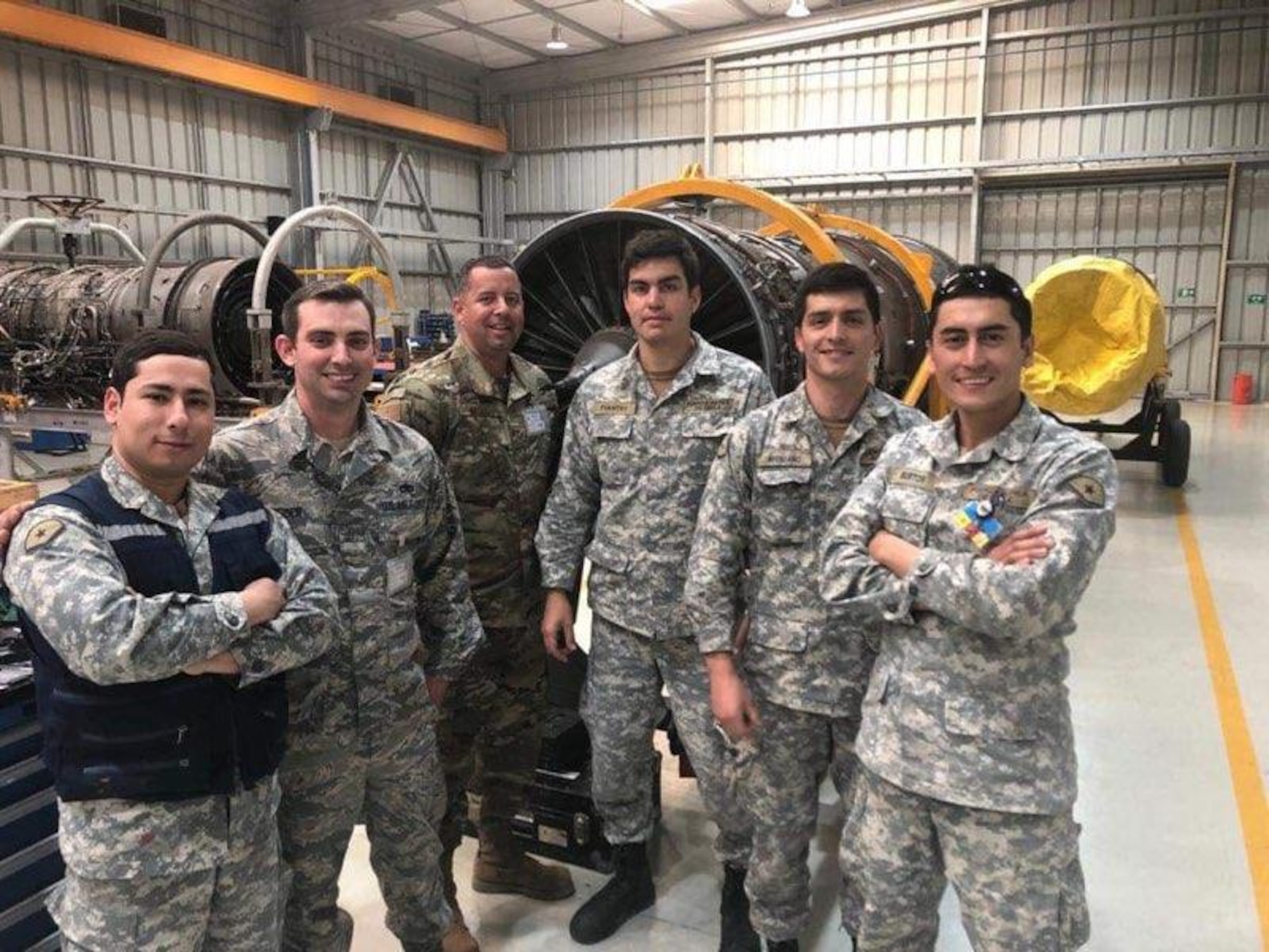 U.S. Air Force Airmen and Chilean airmen stop training to pose for a photo August 26, 2019 at Cerro Moreno Air Base, Chile. The U.S. Airmen were on a temporary duty where they ceritified 15 Chilean airmen on how to perform repairs on F100-Pratt and Whitney-W220 jet engine fan blades. (Courtsey photo)