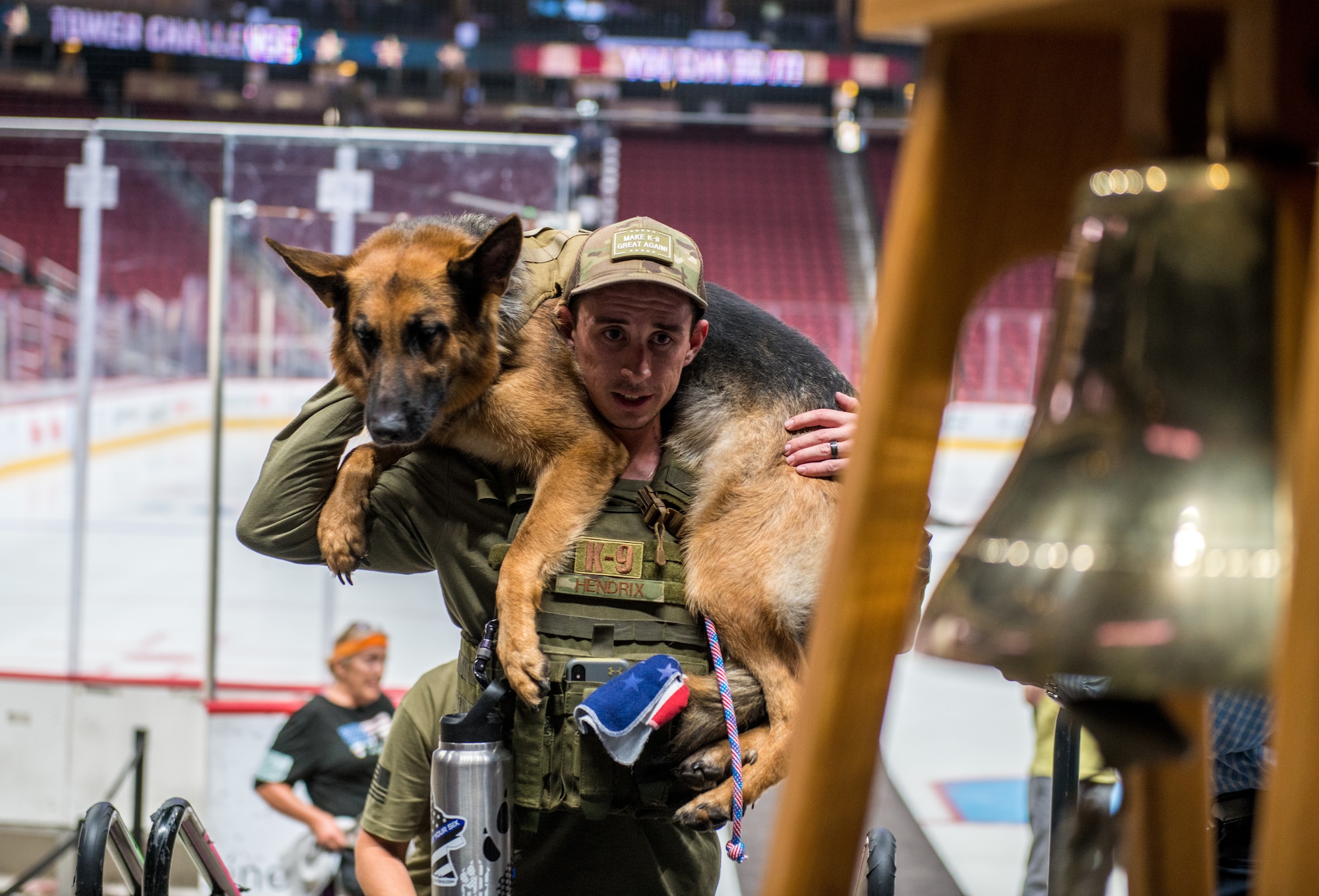 Tech. Sgt. Tyler Hendrix, 56th Security Forces Squadron kennel master, carries a military working dog during the 9/11 Tower Challenge Sept. 11, 2019, at the Gila River Arena, Glendale, Ariz.