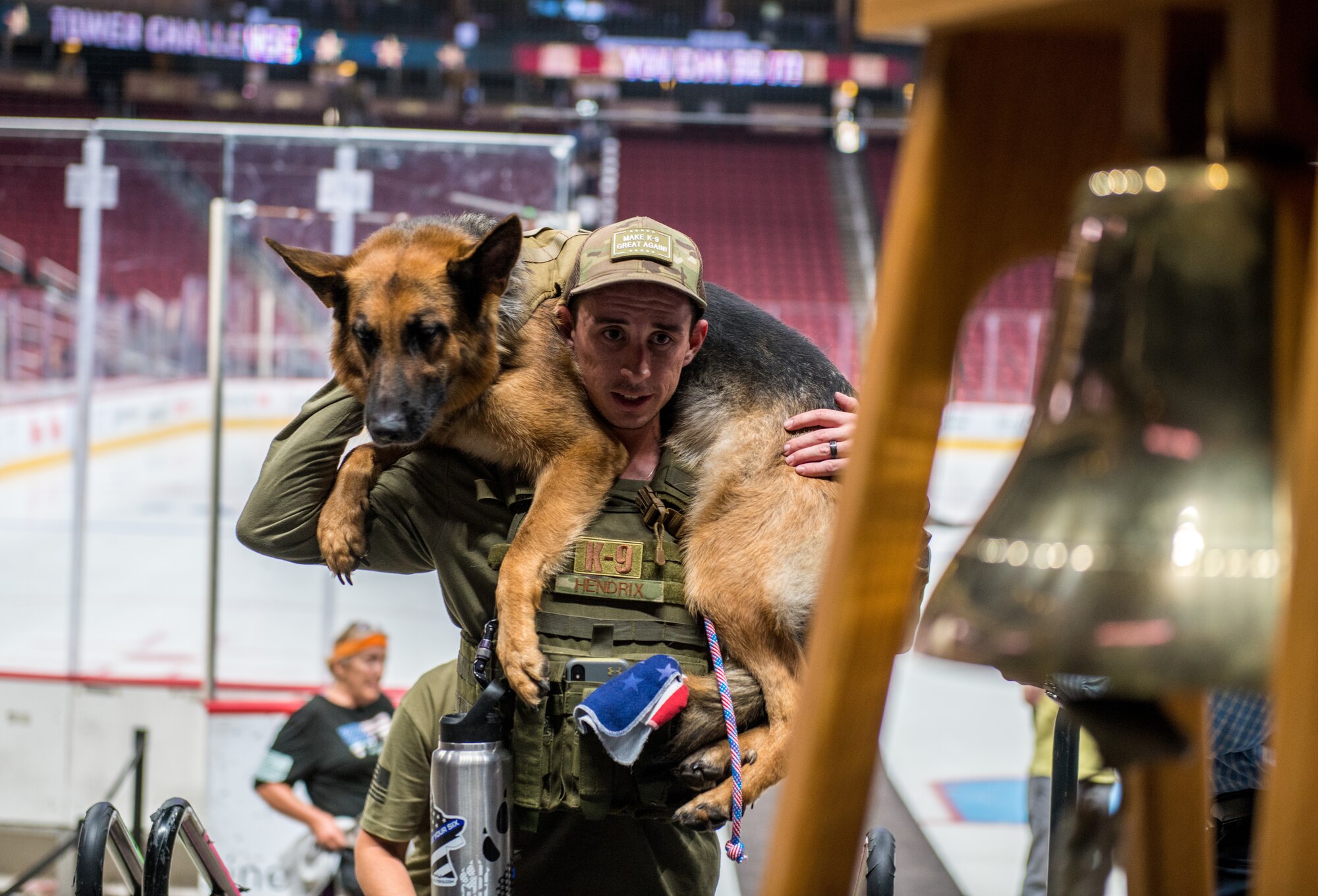 Tech. Sgt. Tyler Hendrix, 56th Security Forces Squadron kennel master, carries a military working dog during the 9/11 Tower Challenge Sept. 11, 2019, at the Gila River Arena, Glendale, Ariz.