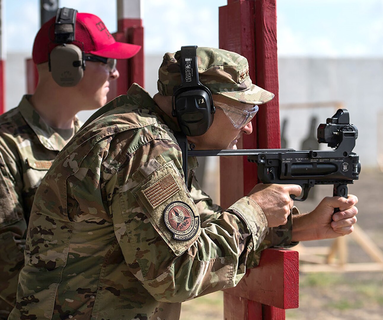 Gen. Arnold W. Bunch, Jr., fires the M320A1 grenade launcher with the ballistic sighting module aiming device with guidance from Staff Sgt. Brett Miner, 37th Training Support Squadron combat arms instructor, at Medina range during his visit to Air Force Materiel Command Units at Joint Base San Antonio Sept. 4.