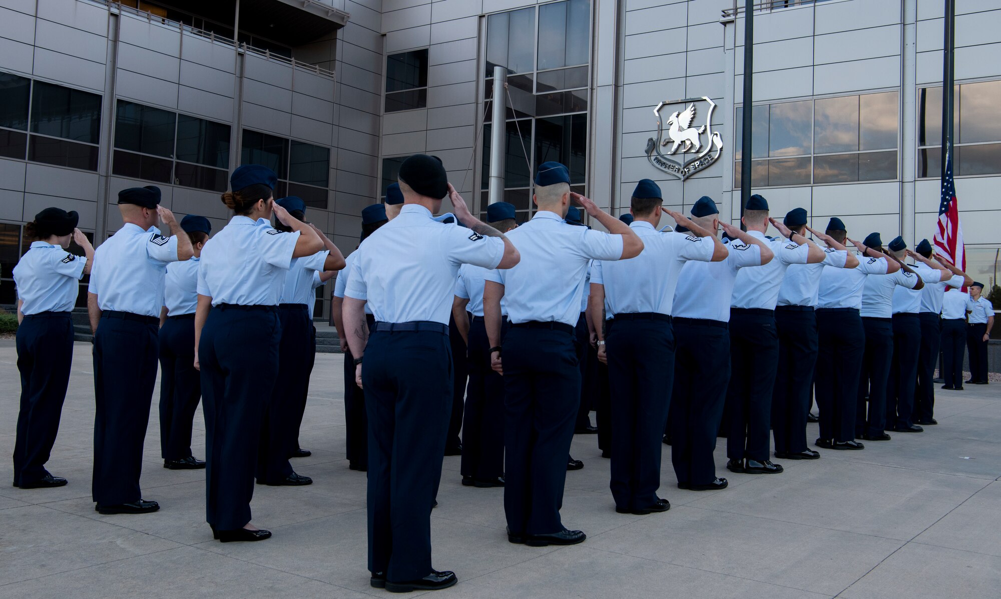 50th Space Wing Airmen salute during a memorial reveille on Sept. 11, 2019, at Schriever Air Force Base, Colorado. Schriever AFB has an artifact from the World Trade Center towers secured by Don Addy, Colorado Thirty Group chairman, so we may never forget what happened that day. (U.S. Air Force photo by Airman 1st Class Jonathan Whitely)