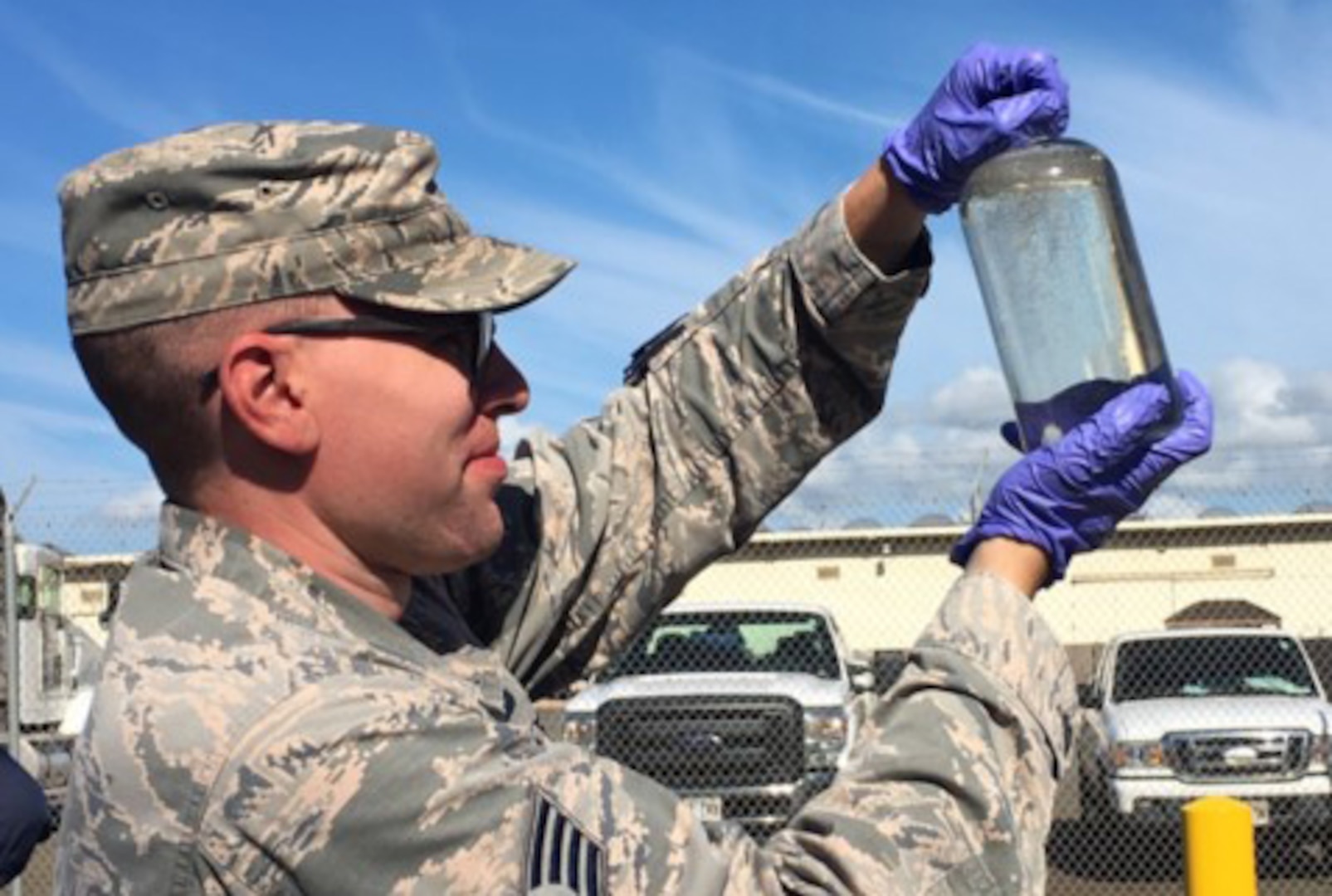 man in uniform examines a fuel sample