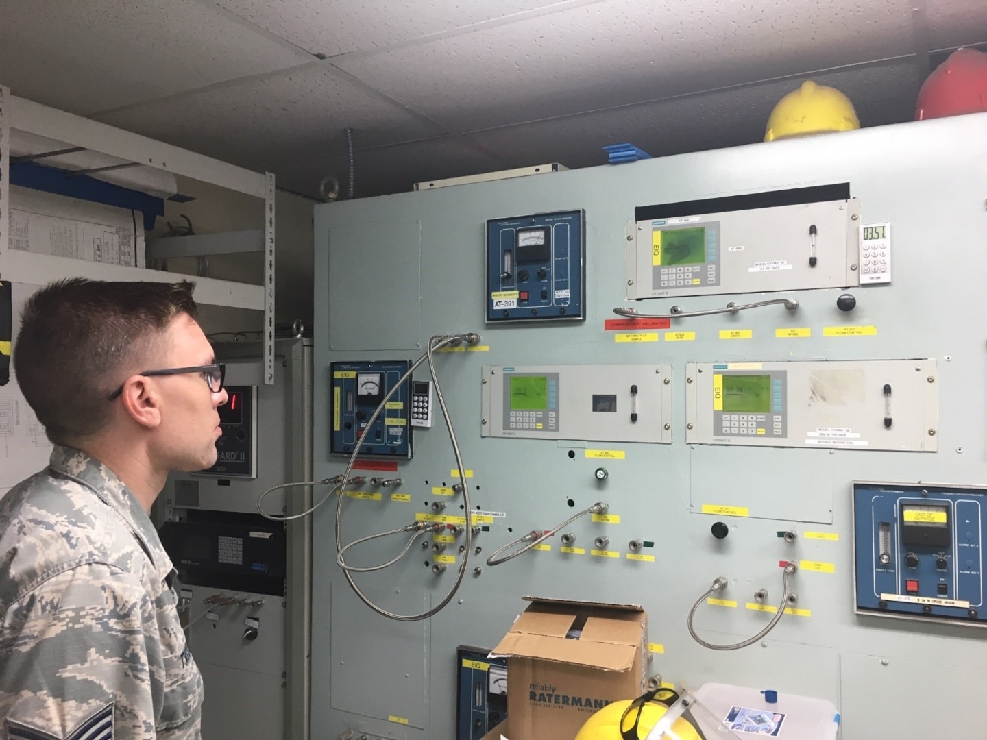 man in uniform looks at a machine