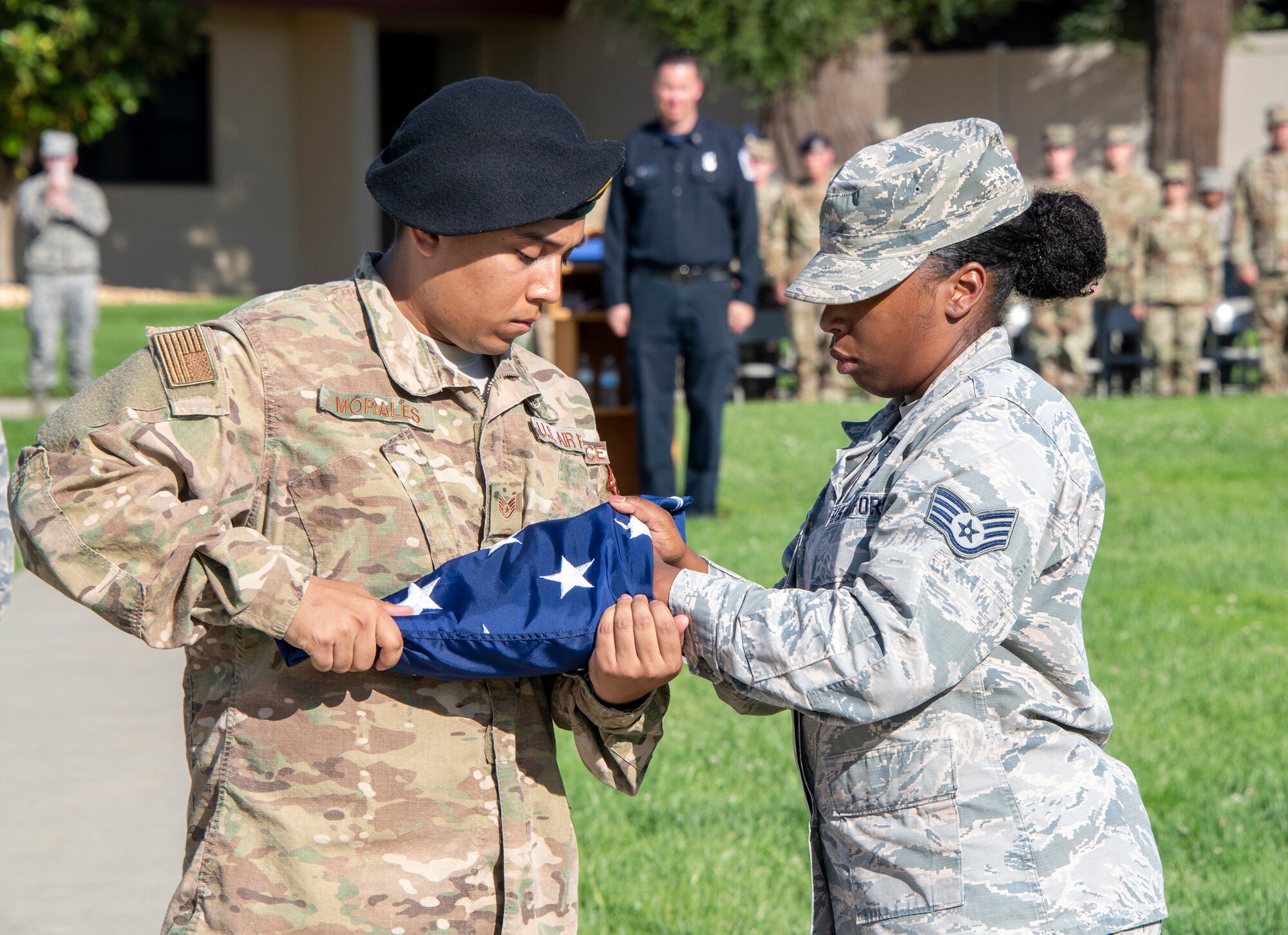 U.S. Air Force Staff Sgts. Mark Morales, 60th Security Forces Squadron installation patrol, and Martina Shannon-Young, 60th Medical Operations Squadron mental health technician, fold the flag during a 9/11 Memorial Retreat Ceremony Sept. 11, 2019, at Travis Air Force Base, California. The ceremony honored the victims of the terrorist attacks on Sept. 11, 2001 and the first responders who risked their lives to save them. (U.S. Air Force photo by Heide Couch)
