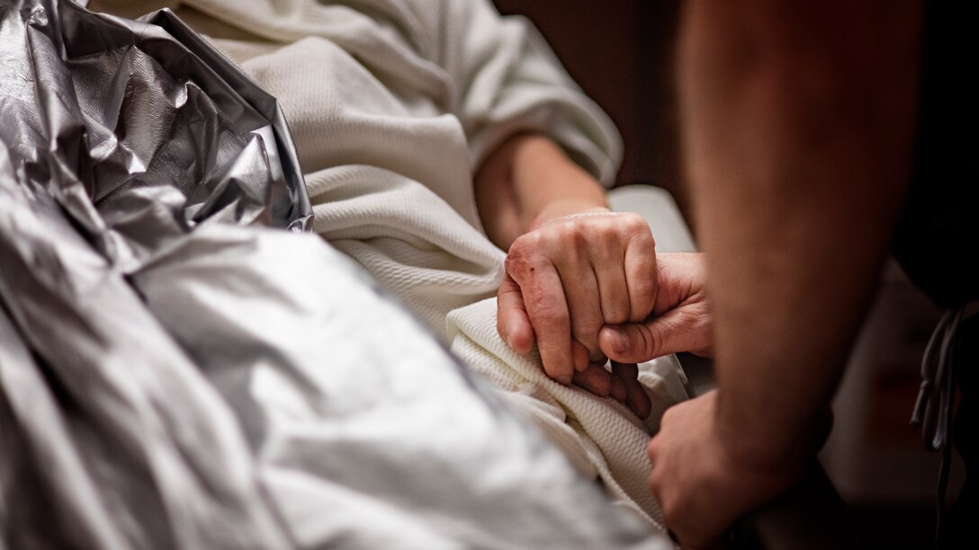 Retired U.S. Army Capt. Katie Blanchard squeezes the hand of Col. (Dr.) Chad Hivnor, 59th Medical Specialty Squadron laser medicine chief, after surgery Sept. 6 at Wilford Hall Ambulatory Surgical Center, Joint Base San Antonio-Lackland. Blanchard estimates she has undergone nearly 200 surgeries since she was burned in a workplace violence incident three years ago.