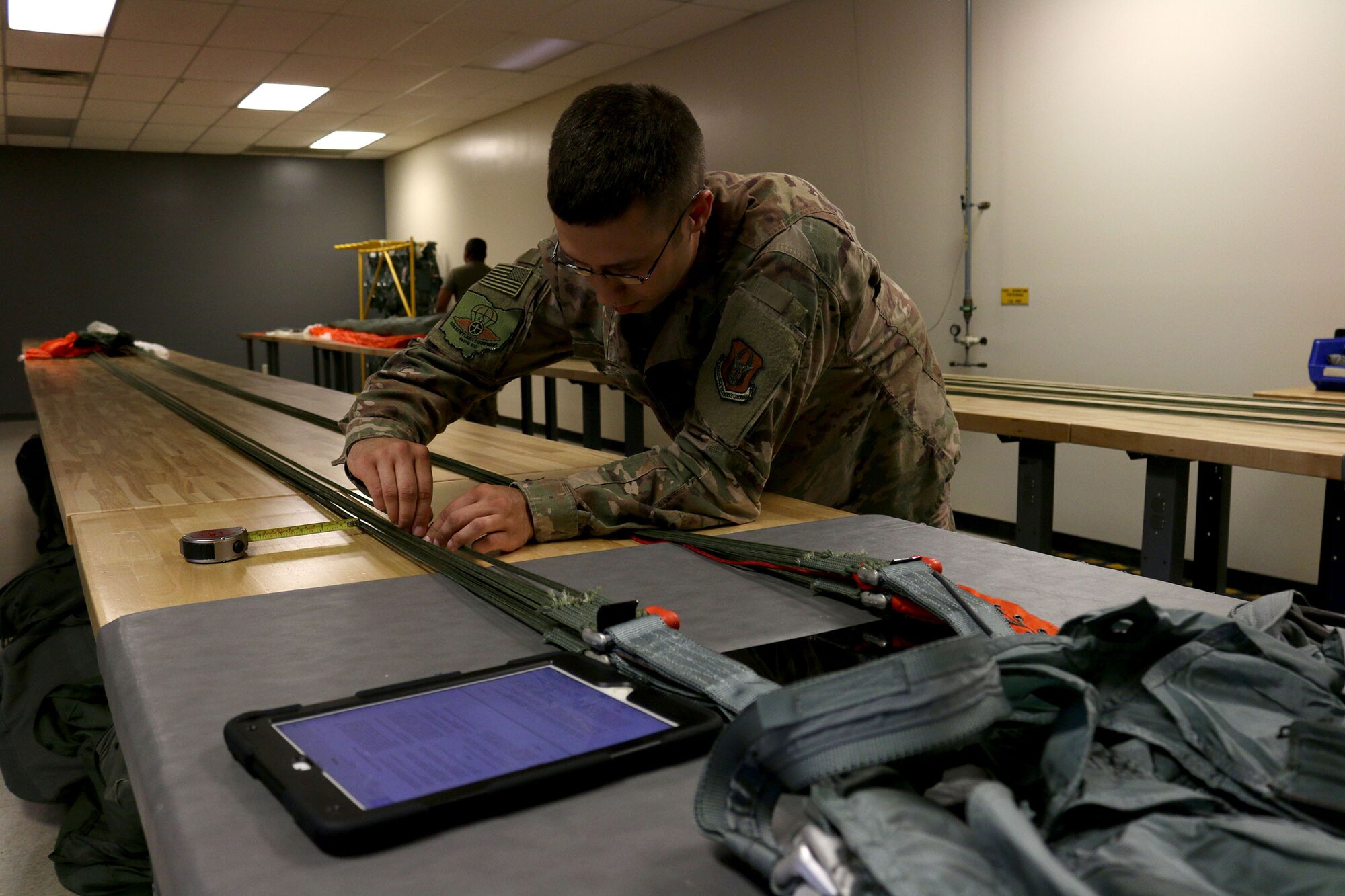 Senior Airman David Smith, 445th Operations Support Squadron, aircrew flight equipment shop, measures the slack in the lines of a BA-22 parachute. If any defects are found in these measurements, the chute is set aside and inspected further. (U.S. Air Force photo/Staff Sgt. Joel McCullough)