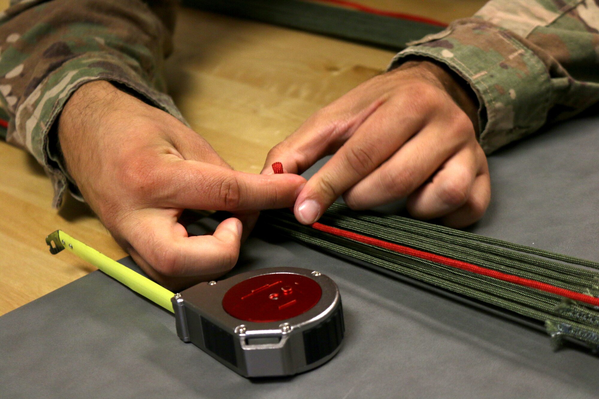 Senior Airman David Smith, 445th Operations Support Squadron, aircrew flight equipment shop, measures the slack in the lines of a BA-22 parachute. If any defects are found in these measurements, the chute is set aside and inspected further. (U.S. Air Force photo/Staff Sgt. Joel McCullough)