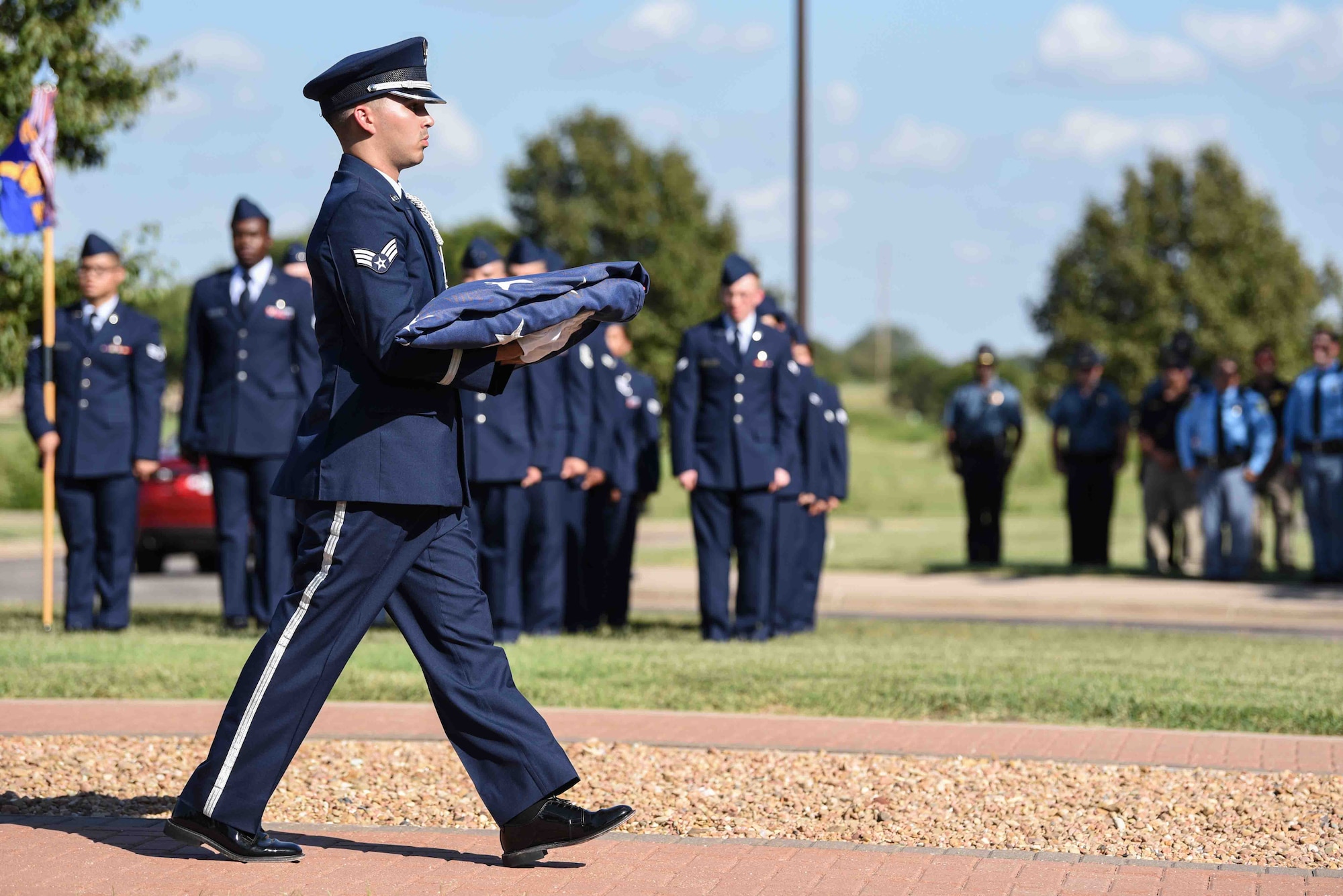 Senior Airman Griffin Rogers, 22nd Force Support Squadron honor guardsman, carries the flag after retreat Sept. 11, 2019, at McConnell Air Force Base, Kan. The Patriot Day Ceremony was held to honor the lives lost during the 9/11 attacks on the World Trade Center. A total of 576 emergency first responders passed away that day, trying to protect the lives of others. (U.S. Air Force photo by Airman 1st Class Alexi Bosarge)