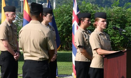 IMAGE: DAHLGREN. Va. (Sept. 11, 2019) – Navy chief select Karly Bengtson shares a story of heroism in response to the terrorist attacks and ensuing tragedies on 9/11. Bengtson was one of seven chief select ‘heroism readers’ based at commands located on Naval Surface Facility Dahlgren who recounted acts of heroism on that tragic day in our nation’s history.

Bengtson – reading to military, first responders, government and contractor personnel gathered to honor the victims of 9/11 – recounted that:
“At approximately 9:28 a.m. on Sep. 11, 2001, United Flight 93 was hijacked by four al Qaeda terrorists. After the terrorists had stabbed the pilot and a flight attendant, the passengers were told that a bomb was onboard and the plane was heading back to the airport. Tom Burnett was speaking to his wife on the phone upon discovering that flights had been hijacked in NYC and had hit the World Trade Center. ‘We have to do something, Burnett told his wife at 9:45 a.m. ‘I'm putting a plan together.’ Other passengers, including Mark Bingham, Jeremy Glick, and Todd Beamer, were learning similar details in their own phone calls. As the plane was barreling towards Washington, D.C., the passengers voted on whether or not to fight back against the hijackers. Led by the four man group, the passengers rushed the cockpit, with Beamer rallying them with his last words: "You ready? Okay, let's roll." Instead of the plane hitting its intended target — believed to be The White House or the Capitol Building — it crashed into an empty
field in Shanksville, Pennsylvania.”